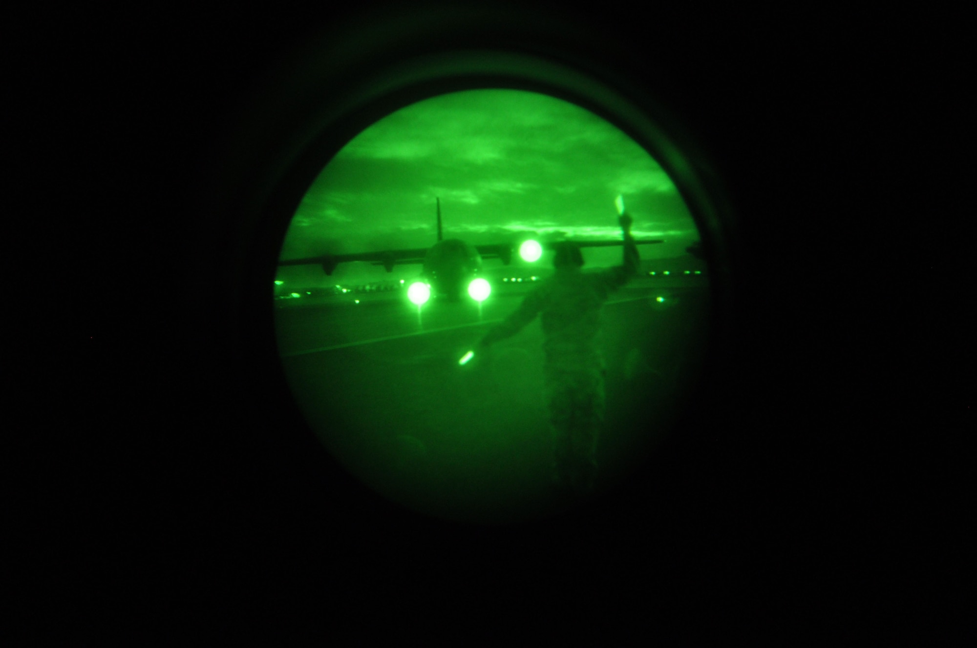 Airman 1st Class Eric Fanslau, 573 Global Support Squadron, marshalls in the aircraft used for Phase III Night Vision Goggle training. The training certified members of the 60th Aerial Port Squadron and 615th Continency Respose wing to conduct night ops downrange. (U.S. Air Force photo/Staff Sgt. Shaun Emery)