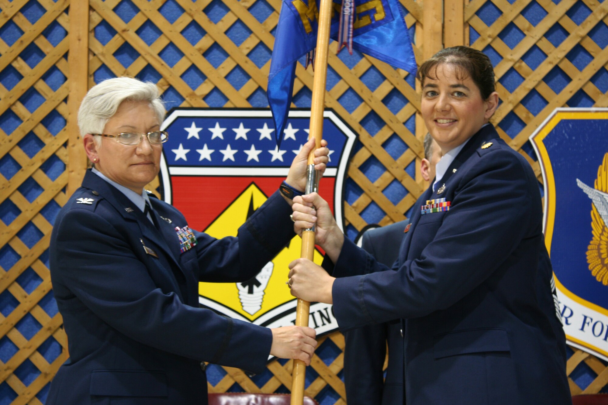 WRIGHT-PATTERSON AIR FORCE BASE, Ohio – Col. Anna Schulte, 445th Maintenance Group commander, passes the guidon to Maj. Suzanne Johnson, incoming 445th Maintenance Squadron commander, during the May 2 change of command ceremony.  Maj. Jay Smeltzer relinquished command of the MXS to Major Johnson after serving in the position since August of 2008.  Major Johnson was previously assigned as the quality assurance officer for 445th Maintenance Group. (U.S. Air Force photo/Staff Sgt. Amanda Duncan)