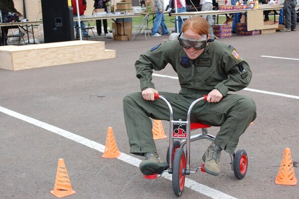 1st Lt. Stephanie Olson, 40th Helicopter Squadron, tries navigating her way through an obstacle course on a tricycle while wearing "beer goggles" which simulate the effects of being under the influence of alcohol. It was one of the events available for participants at the Rolling Thunder motorcycle safety day April 23. (U.S. Air Force photo/Valerie Mullett)