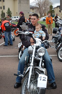 Staff Sgt. Emmanuel Martinez hold his 7-month-old son Manny, while sitting on his motorcycle. He would later find out his bike was voted the best and earn him a first place trophy. (U.S. Air Force photo/Valerie Mullett)