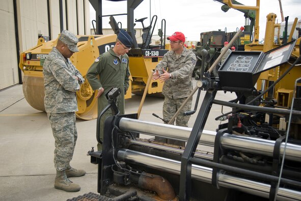 Staff Sgt. Christopher D'Angelo explains the capabilities of the asphalt paver to 341st Missile Wing leadership, Vice Commander Col. Anthony Cotton, (left), and Commander Col. Michael Fortney (center), during an 891th RED HORSE Squadron open house April 27. Sergeant D'Angelo is a heavy equipment operator and the paver is his specialty. (U.S. Air Force photo/Beau Wade)