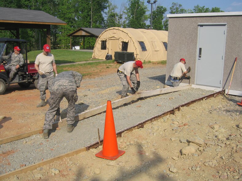 Airmen from the structures shop of the 567th Red Horse Squadron pour a walkway to their communications building during a recent annual tour. (USAF photo courtesy of 567 RHS)