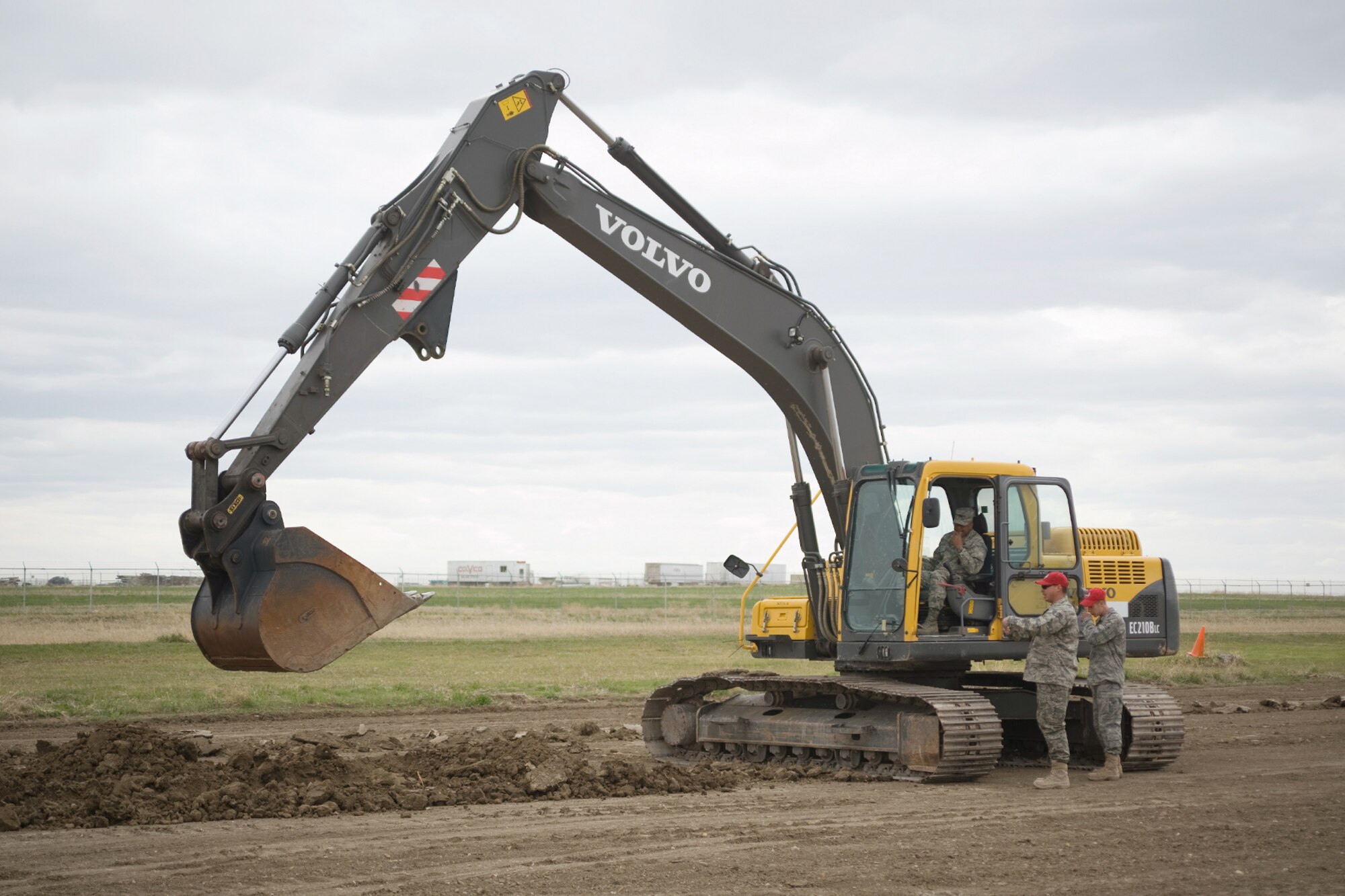 Col. Anthony Cotton operates an excavator after Staff Sgt. Nicholas Atencio and Amn Cody Holly give him soe quick training during the 819th RED HORSE Squadron open house April 27. (U.S. Air Force photo/Beau Wade)