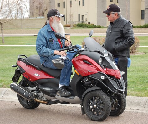 Allan (Chief) Metzger chats with Hank Wilczek during Rolling Thunder activities April 23 at the Health and Wellness Center parking lot. Mr. Metzger is sitting on an MP3 scooter made by Piaggio. He is the owner of Metzger's Cycles & Accessories. (U.S. Air Force photo/Valerie Mullett)