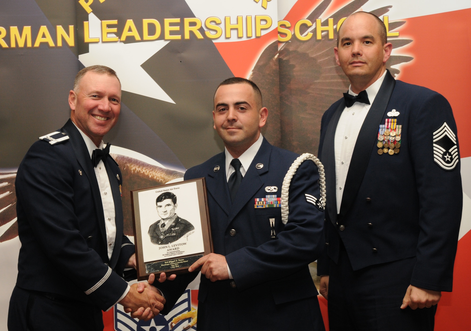 SPANGDAHLEM AIR BASE, Germany -- Senior Airman Miguel Torres, 52nd Equipment Maintenance Squadron, accepts the John L. Levitow Award from Col. Tip Wight, 52nd Fighter Wing commander; Chief Master Sgt. Michael Irons, 52nd Civil Engineer Squadron chief enlisted manager, during the Pitsenbarger Airman Leadership School Class 10-5 graduation in Club Eifel May 5. The John L. Levitow award is the highest level award an Airman can receive upon completion of ALS. (U.S. Air Force photo/Airman 1st Class Nick Wilson)