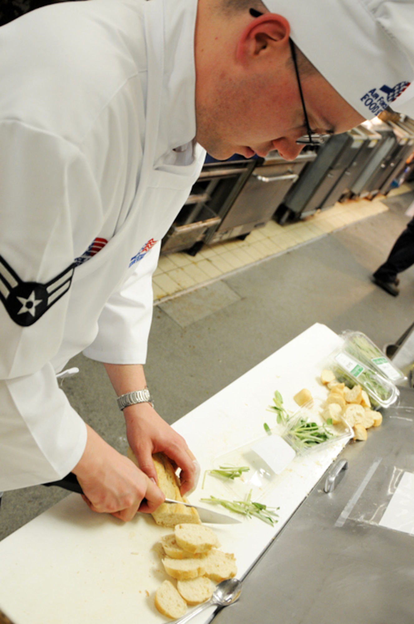 Airman 1st Class Benjamin Kerchner, Knight’s Table blue team member, slices the garnish bread for the lobster bisque entrée garnish at the Liberty Club at RAF Lakenheath, England, April 24. The second annual Hell’s kitchen cook-off consisted of two, five-member teams, one military and one civilian. Each team created a menu of their own and were judged by designated judges, customers and mystery judges. Despite last year’s defeat the military team took home the victory this year. (U.S. Air Force photo by Airman 1st Class Lausanne Morgan)