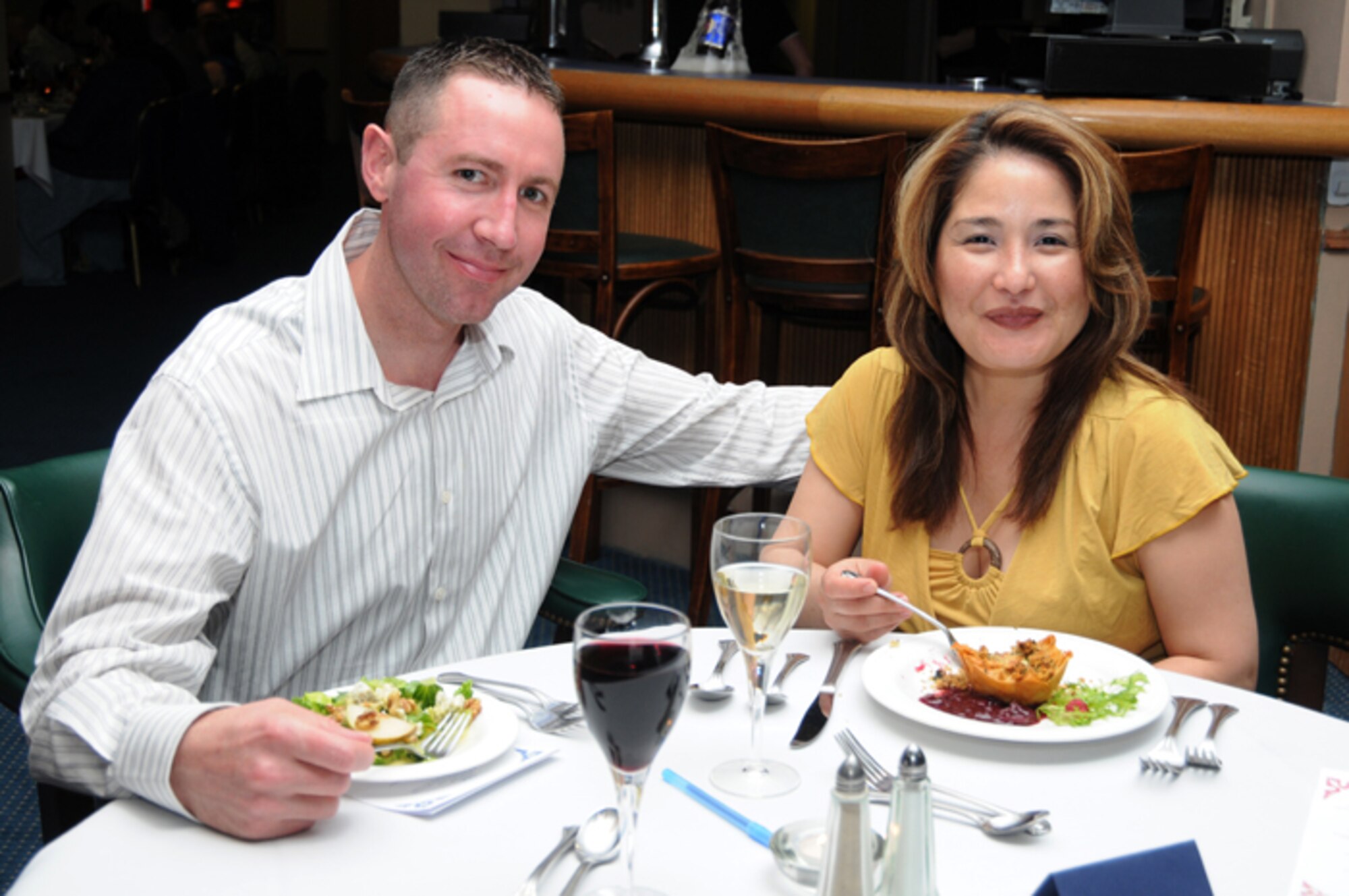 Senior Master Sgt. Jeremy Kremenauer and his wife enjoy a gourmet meal at the Hell’s kitchen cook-off prepared by two opposing teams at the Liberty Club at RAF Lakenheath, England, April 24. Each team created a gourmet menu of their own and were judged by designated judges, customers and mystery judges. With something to prove from last years’ defeat, the military chefs took home the victory over the civilians this year. (U.S. Air Force photo by Airman 1st Class Lausanne Morgan)