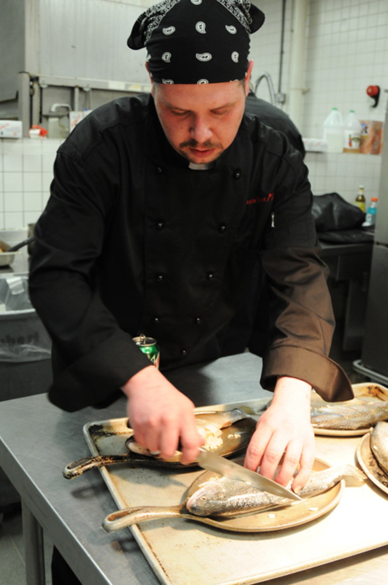 Dustin Roox, Liberty Club red team member, scours the stuffed rainbow trout at the Liberty Club at RAF Lakenheath, England, April 24. The second annual Hell’s kitchen cook-off consisted of two, five-member teams, one military and one civilian. Each team created a menu of their own and were judged by designated judges, customers and mystery judges. While the civilians won the competition last year, the military team took the win this year.  (U.S. Air Force photo by Airman 1st Class Lausanne Morgan)