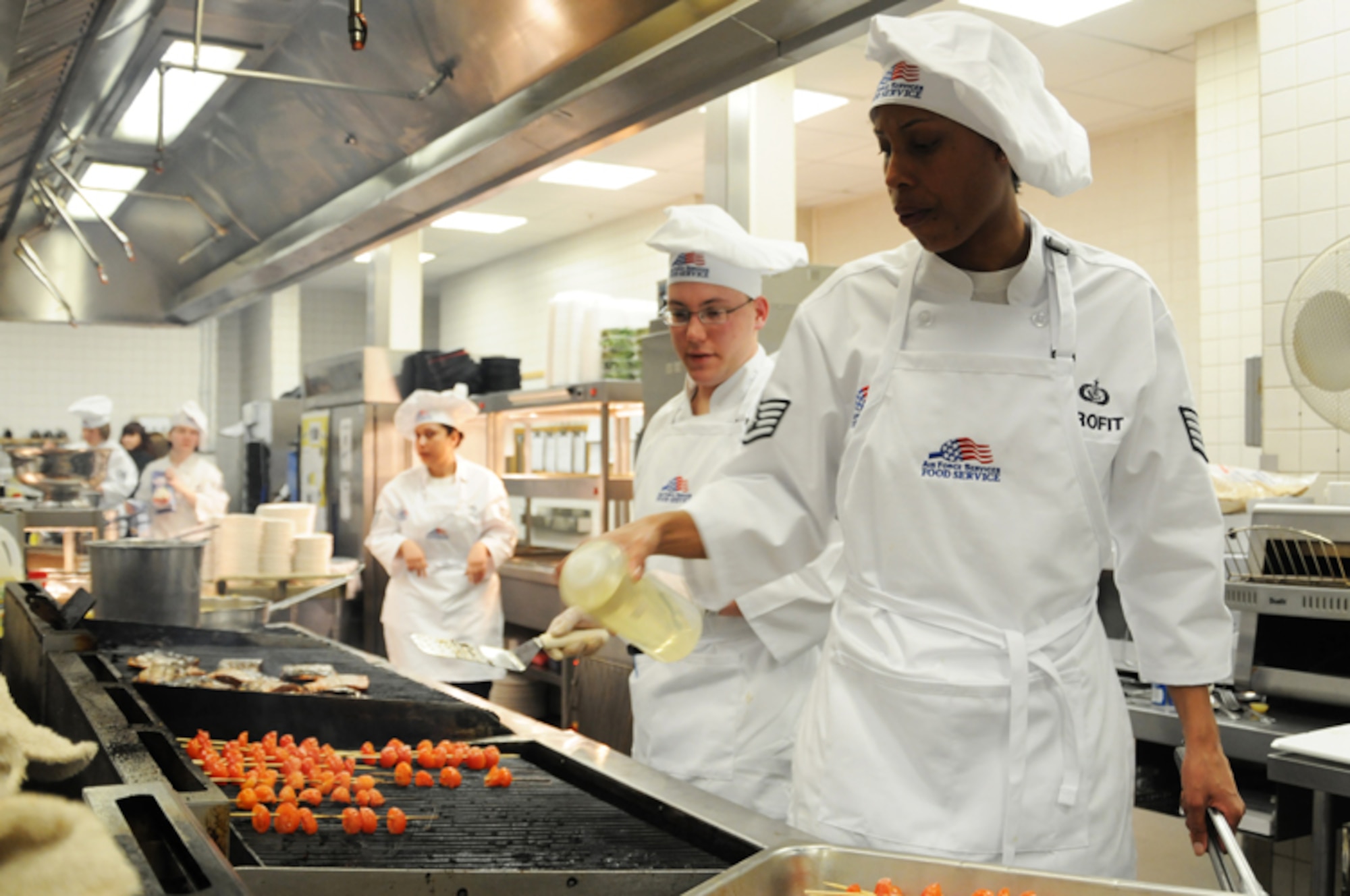 Staff Sgt. Janeithia Profit, Knight’s table blue team member, seasons skewered tomatoes on the grill to be used as a garnish at the Hell’s kitchen cook-off at the Liberty Club at RAF Lakenheath, England, April 24. Sergeant Profit was a member of the blue which was made up of military chefs. Both teams created unique gourmet menus to be judged by designated judges, customers and mystery judges. The military chefs won the competition this year. (U.S. Air Force photo/Airman 1st Class Lausanne Morgan)