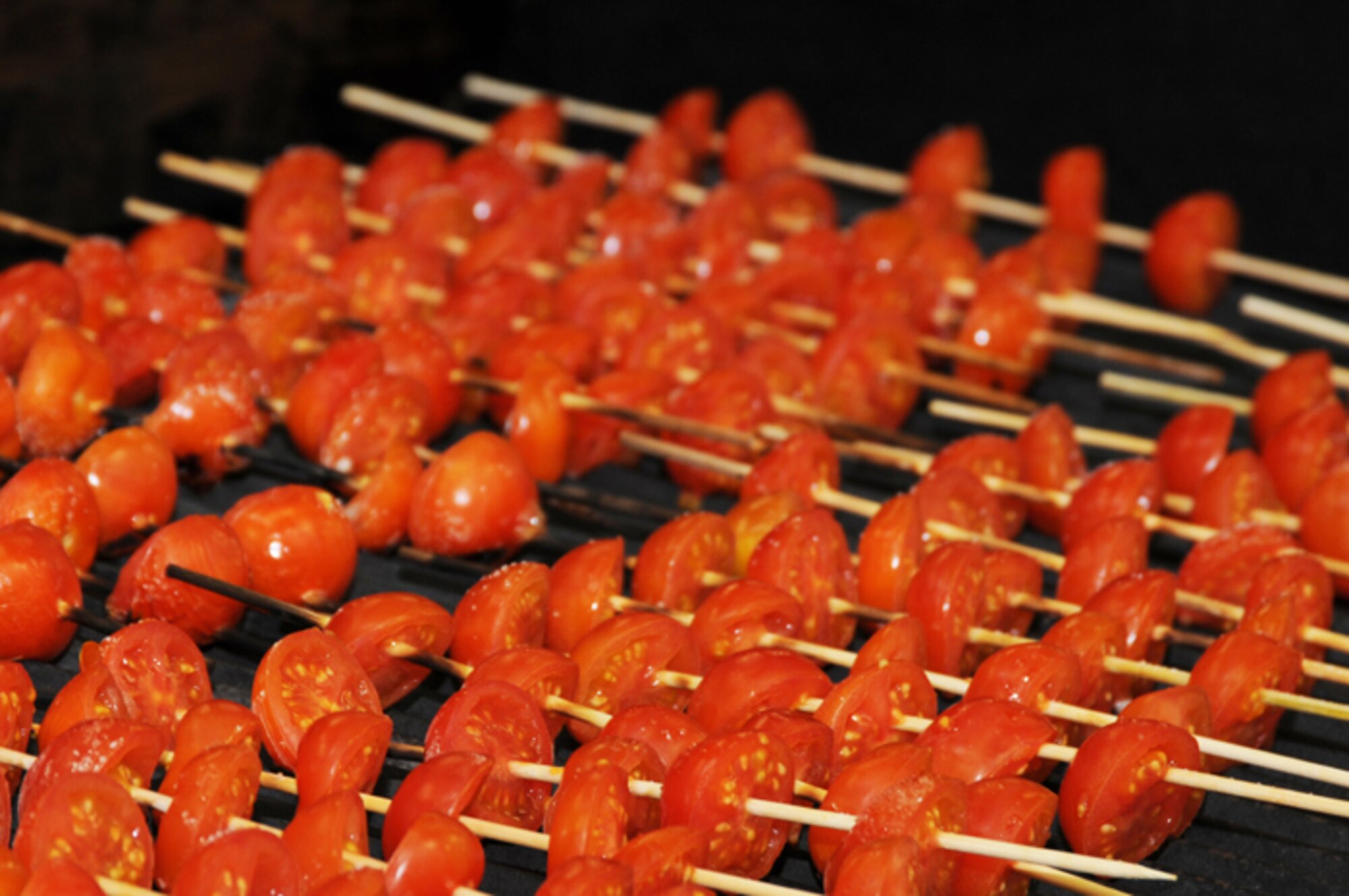 Skewered tomatoes charbroil on a grill to be used as a garnish at the Liberty Club at RAF Lakenheath, England, April 24. The tomatoes were a small part of the second annual Hell’s kitchen cook-off which consisted of two, five- member teams, one military and one civilian. Each team created a menu of their own and was judged by designated judges, customers and mystery judges. With something to prove from last year’s defeat the military chefs took home the victory this year. (U.S. Air Force photo/Airman 1st Class Lausanne Morgan)