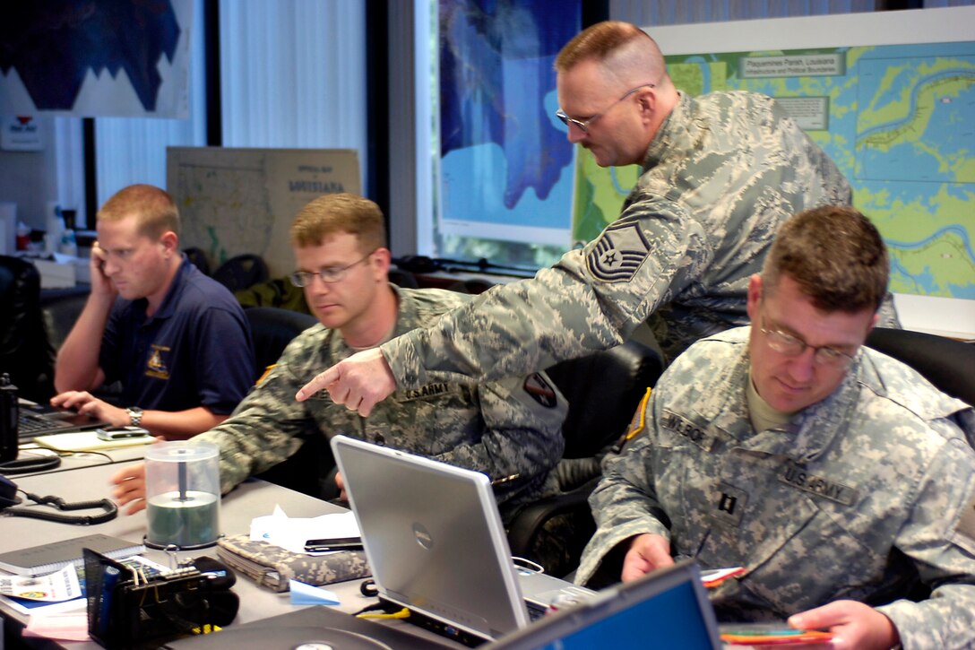 Nathan A. Elkins, assistant regional coordinator of the Governor’s Office of Homeland Security and Emergency Preparedness, and Louisiana National Guardsmen discuss the day’s missions at the Plaquemines Parish Office of Homeland Security and Emergency Preparedness in Belle Chasse, La., May 6, in support of the oil spill response.
