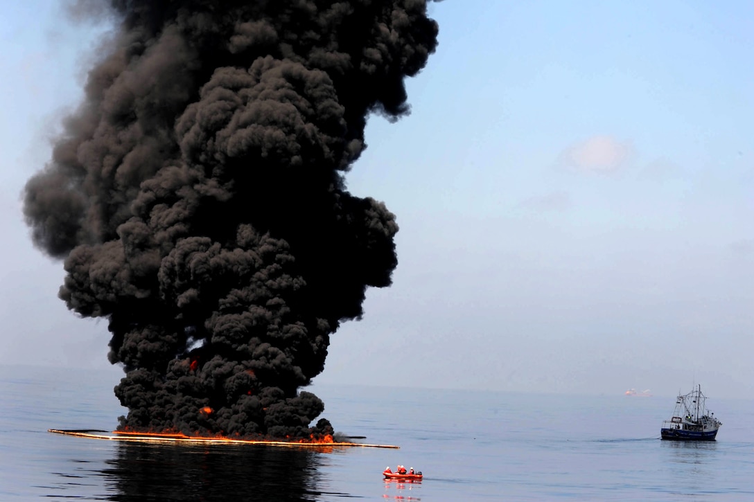 Dark clouds of smoke and fire emerge as oil burns during a controlled fire in the Gulf of Mexico, May 6, 2010. The U.S. Coast Guard, working with BP, local residents and other federal agencies, conducted the burn to help prevent the spread of oil following the explosion on Deepwater Horizon, an offshore drilling unit.