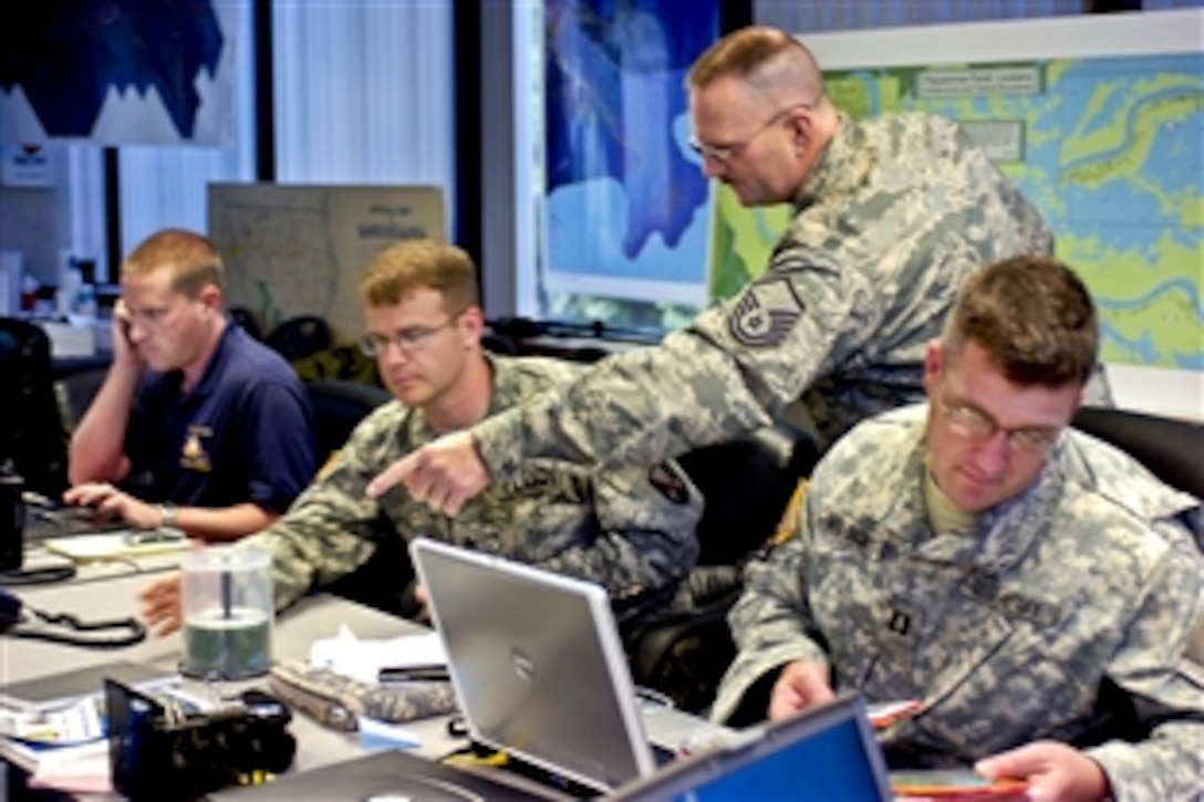 Nathan A. Elkins, assistant regional coordinator of the Governor’s Office of Homeland Security and Emergency Preparedness, and Louisiana National Guardsmen discuss the day's mission to help contain the oil spill in the Gulf of Mexico in Belle Chasse, La., May 6, 2010.