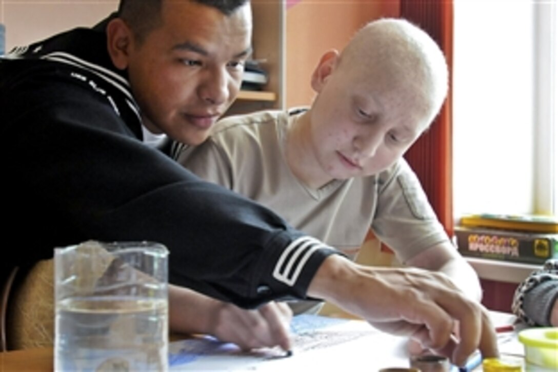 U.S. Navy Seaman Sergio Torres draws pictures with a child at the Vladivostok children's cancer ward in Vladivostok, Russia, May 7, 2010. Sailors from the USS Blue Ridge will be engaged in  community outreach events in Vladivostok and will march with members of the Russian military during a parade to commemorate the 65th anniversary of Victory Day, a national holiday in Russia.