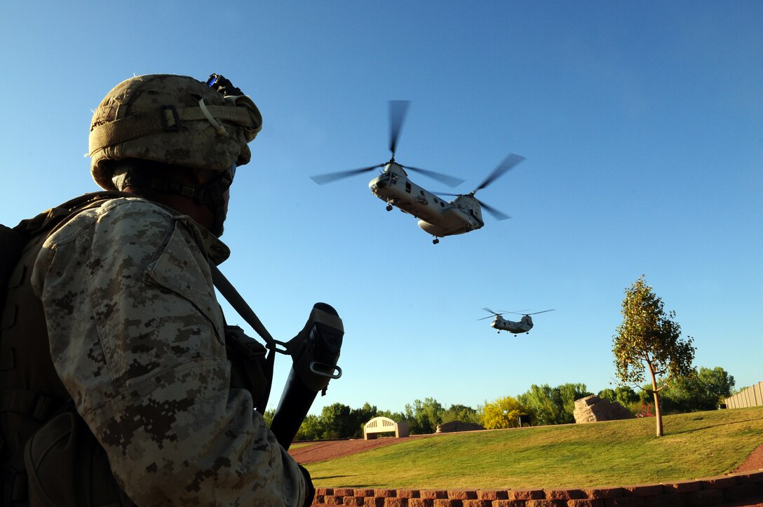 Lance Cpl. Jaime Hernandez, an infantryman with Company B, 1st Battalion, 1st Marine Regiment, watches two CH-46 Sea Knight helicopters fly in to land as Company B creates a perimeter for the landing zone at West Wetlands Park in Yuma, Ariz., during a noncombatant evacuation operation exercise May 7, 2010. The exercise is part of the Weapons and Tactics Instructor course and takes place in the city of Yuma to provide Marines a realistic urban setting. WTI is hosted semiannually by Marine Aviation Weapons and Tactics Squadron 1.