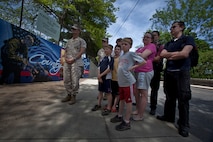 Groups of Bostonians admire the Marine Corps mural at Hyde Park on their way to the Red Sox game May 7, 2010. The mural is displayed as a testament to Marine Week Boston and is a reminder of the Marines' service to the community, said Heidi Schork, the director of the mayor's mural crew. Planning for the mural began months in advance and Marines stated painting at the park only two weeks ago. Combat camera Marines from across the Corps, who worked on the mural, said it was a unique opportunity to show Bostonians a liter side of the Corps. ::r::::n::