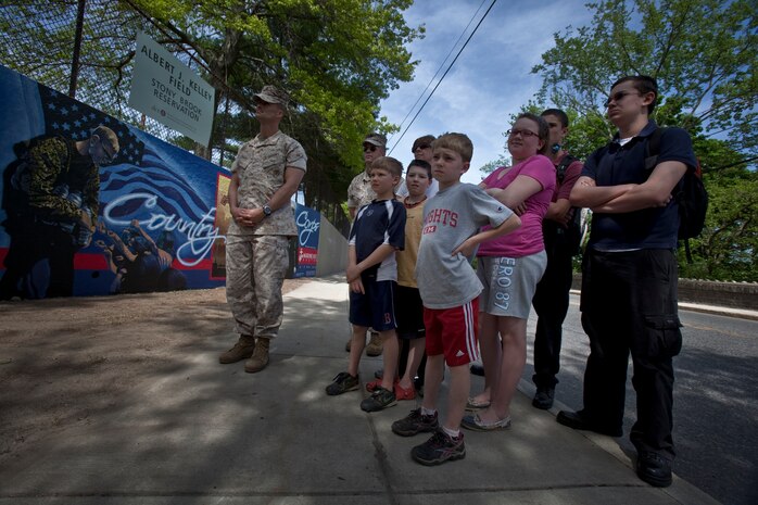 Groups of Bostonians admire the Marine Corps mural at Hyde Park on their way to the Red Sox game May 7, 2010. The mural is displayed as a testament to Marine Week Boston and is a reminder of the Marines' service to the community, said Heidi Schork, the director of the mayor's mural crew. Planning for the mural began months in advance and Marines stated painting at the park only two weeks ago. Combat camera Marines from across the Corps, who worked on the mural, said it was a unique opportunity to show Bostonians a liter side of the Corps. ::r::::n::