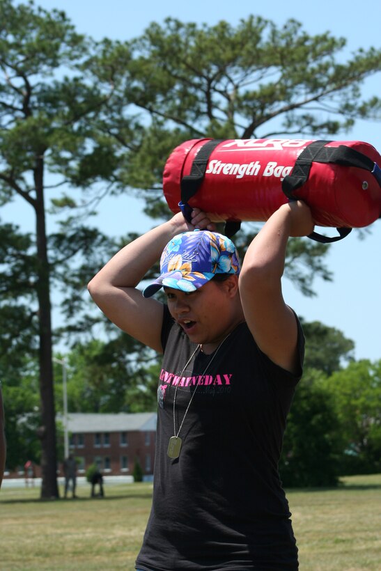 Sasha Leblanc lifts a strenght bag over her shoulders as the first participant in the  modified Combat Fitness Test during the first joint Jane Wayne Day between Marine Aircraft Group 14 and Marine Attack Squadrons 223 and 542, here May 7.  (U.S. Marine Corps photo by Staff Sgt. Roman Yurek)
