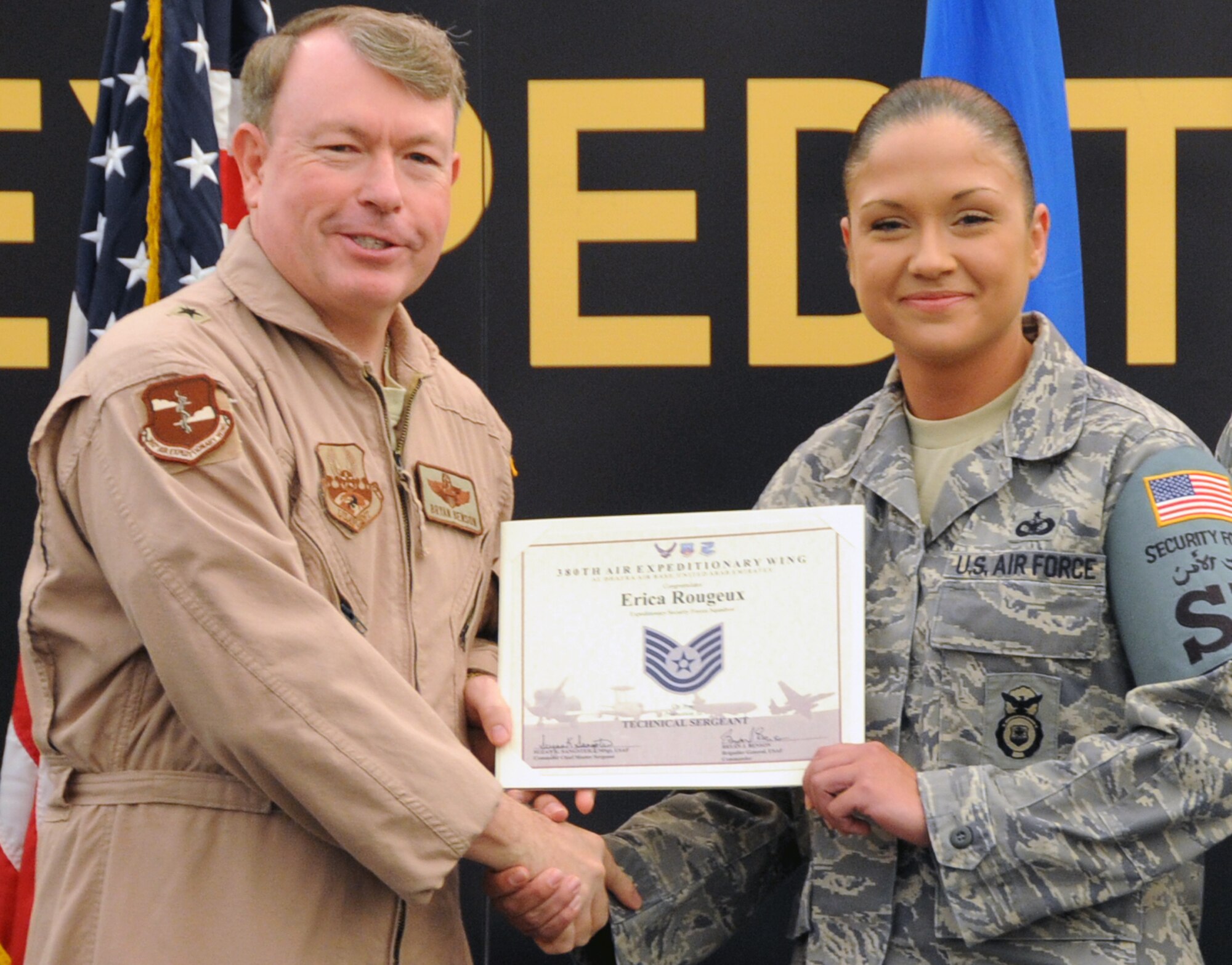 Brig. Gen. Bryan Benson, 380th Air Expeditionary Wing commander, presents a promotion certificate to Tech. Sgt. Erica Rougeux during the wing promotion ceremony at a non-disclosed base in Southwest Asia on May 1, 2010. Sergeant Rougeux was promoted to technical sergeant during the ceremony.  She is deployed from the 81st Security Forces Squadron at Keesler Air Force Base, Miss., and her hometown is San Diego, Calif. (U.S. Air Force Photo/Senior Airman Jenifer H. Calhoun/Released)