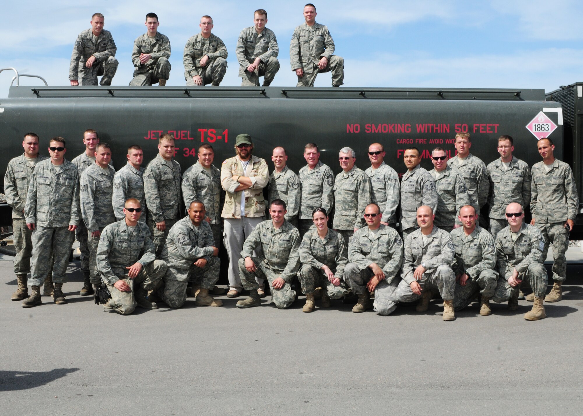 Toby Keith pauses for a photo op with 376th Expeditionary Logistics Readiness Squadron petroleum, oil and lubricants Airmen from the Transit Center at Manas, Kyrgyzstan, during a USO tour here May 7, 2010. (U.S. Air Force photo/ Senior Airman Nichelle Anderson)
