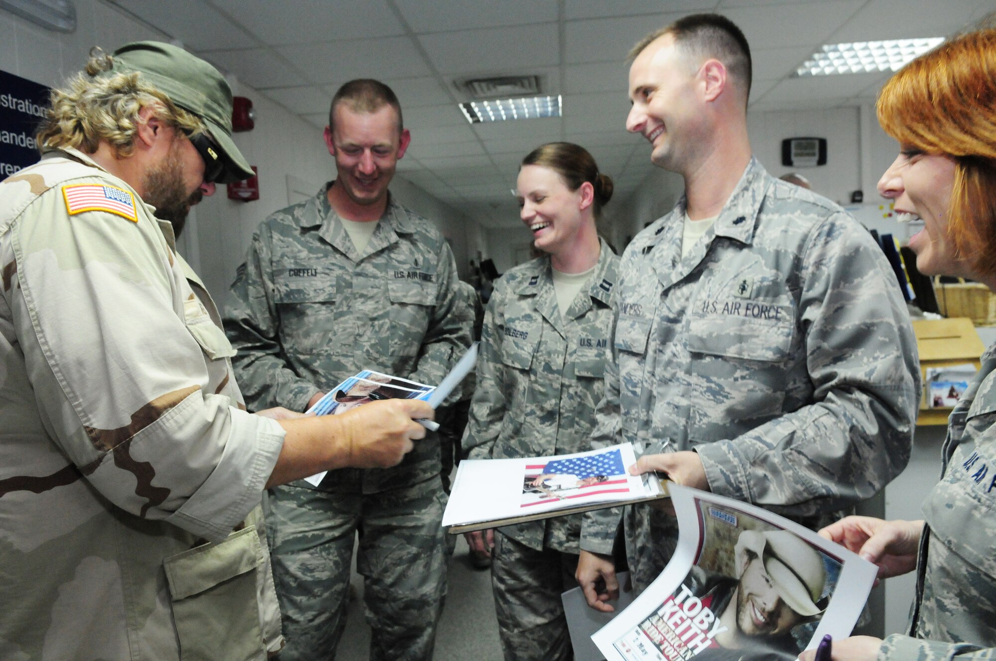 Toby Keith signs posters at the 376th Expeditionary Medical Group during a USO tour of the Transit Center at Manas, Kyrgyzstan, May 7, 2010. (U.S. Air Force photo/ Senior Airman Nichelle Anderson)