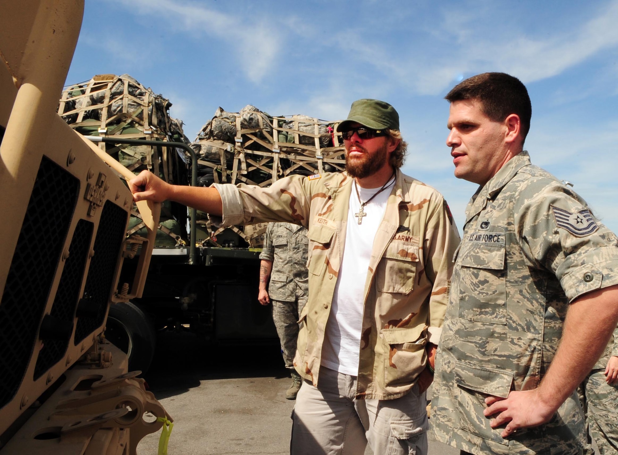 Tech. Sgt. Matt Sollars, right, shows Toby Keith the Air Terminal Operations Center yard, where M-ATVs are waiting to be shipped to Afghanistan, during a USO tour at the Transit Center at Manas, Kyrgyzstan, May 7, 2010. (U.S. Air Force photo/Staff Sgt. Carolyn Viss)