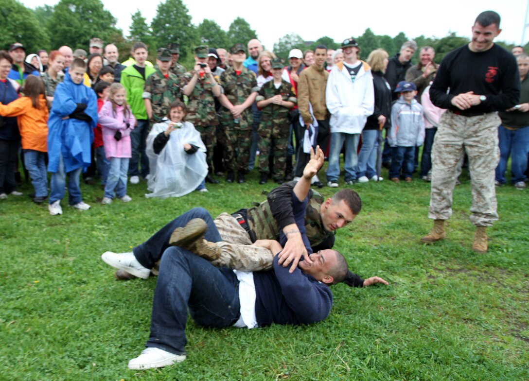 Sgt. Andrew B. Chavis, a martial arts instructor trainer from Marine Corps Base Quantico, Va., ground fights a Boston resident, who volunteered, during a Marine Corps Martial Arts Program demonstration at Marine Week family day at Joe Moakley Park in Boston, Mass., May 8, 2010.