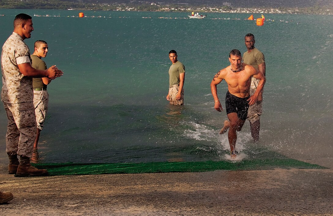 John Akana, the overall winner of the Commanding Officer’s Fitness Series’ Sprint Triathlon rushes out of Kaneohe Bay after his 500-meter portion, Lance Cpl. Ronald W. Stauffer.