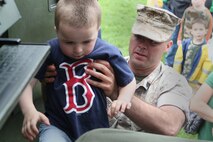 Sgt. Joseph Curtis, 2nd Battalion, 14th Marines, Huntsville, Al., lifts a young boy into a HIMARS Rocket Launcher at Joe Moakley Park, Boston during a static display set up for Marine Week Boston, May 8, 2010. Marine Week provides an opportunity to increase public awareness of the Marine Corps' value to our nation's defense and to preserve and mature the Corps' relationship with the American people.