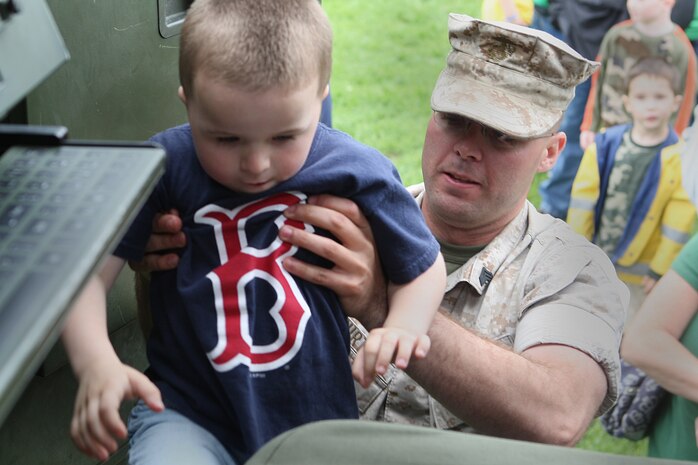 Sgt. Joseph Curtis, 2nd Battalion, 14th Marines, Huntsville, Al., lifts a young boy into a HIMARS Rocket Launcher at Joe Moakley Park, Boston during a static display set up for Marine Week Boston, May 8, 2010. Marine Week provides an opportunity to increase public awareness of the Marine Corps' value to our nation's defense and to preserve and mature the Corps' relationship with the American people.