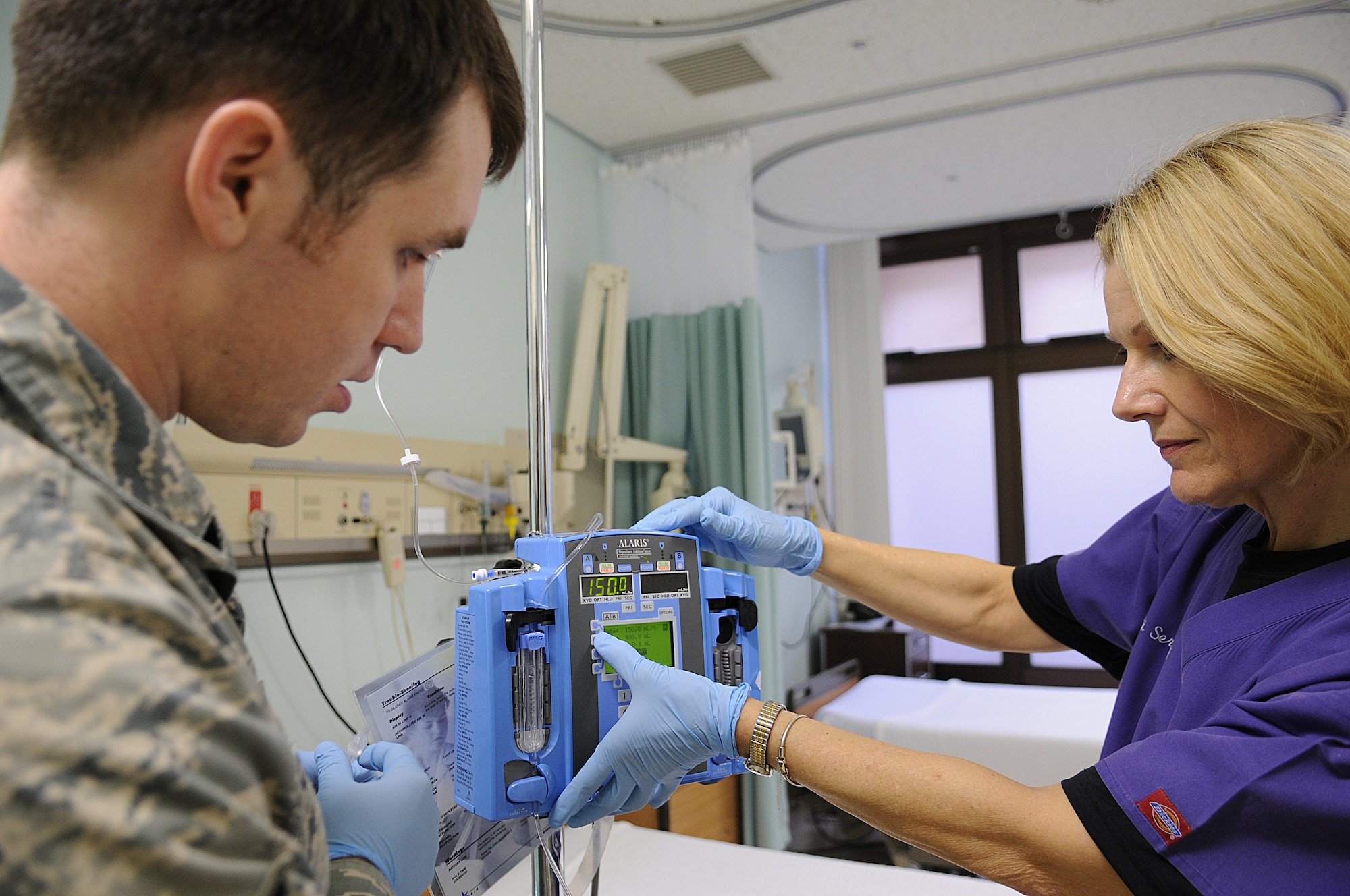 35th Surgical Operations Squadron Airmen, Maj. Carol Marta, infection control officer and clinical nurse, and Senior Airman Andrew Schaub, medical technician, prepares an intravenous machine for patient admission, May 11 at the 35th Medical Group hospital.  In honor of Nurses’ Appreciation Week, nationally celebrated May 6 to 12, the 35th Medical Group honors nurses and medical technicians who serve the Misawa Air Base community. (U.S. Air Force photo/Senior Airman Jessica Lockoski)