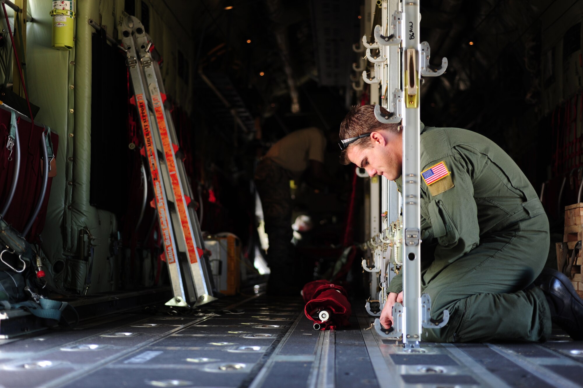 U.S. Air Force Staff Sgt. Brett Hunter, 37th Airlift Squadron loadmaster, assembles jump seats in a C-130J for Romanian paratroopers during a joint exercise, Otopeni  Airlift Wing, Romania, May 10, 2010. Members of U.S. and Romanian Air Forces built partnership capabilities during the weeklong exercise Carpathian Summer 2010. (U.S. Air Force Photo by Staff Sgt. Jocelyn Rich)