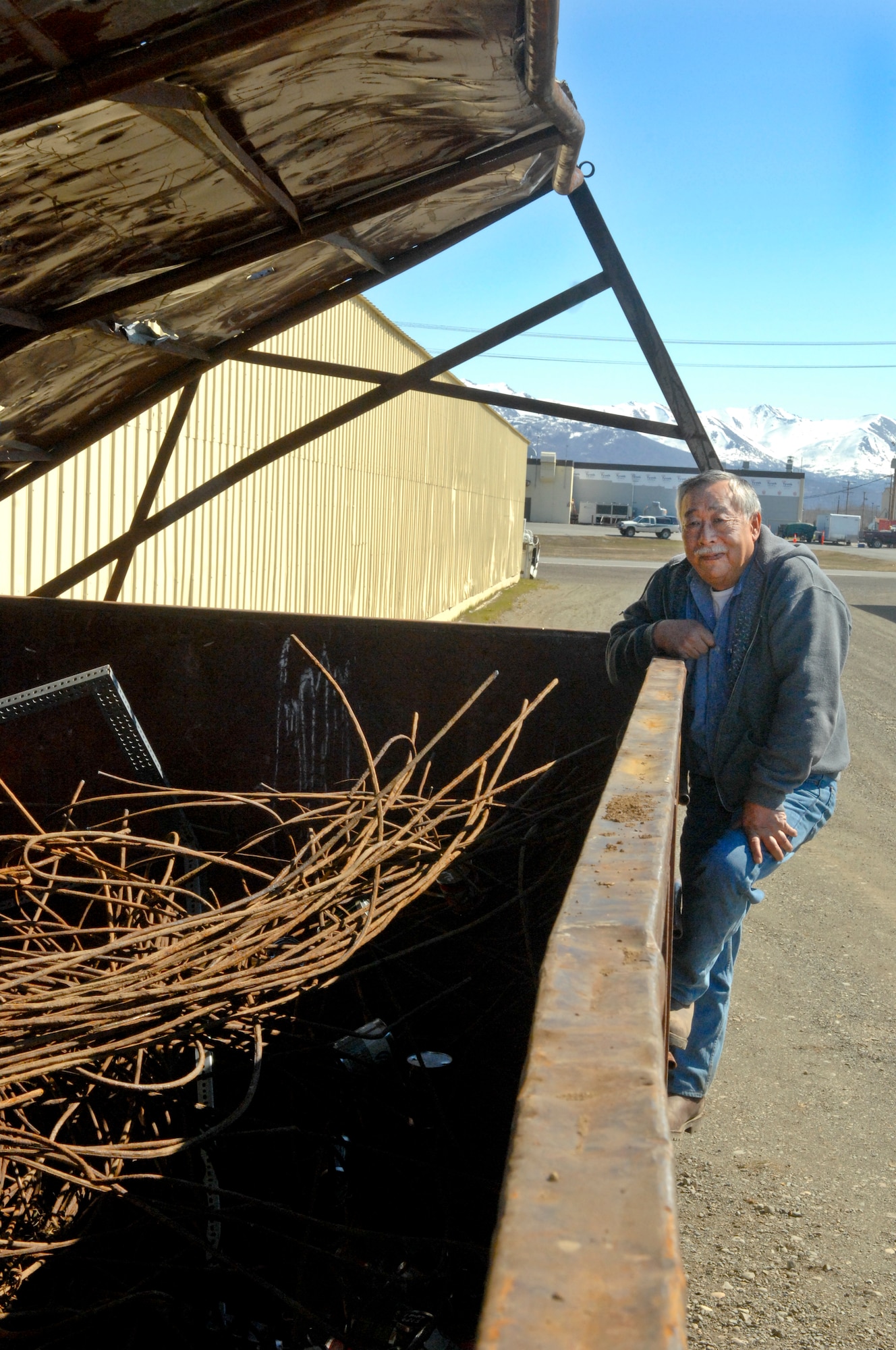 ELMENDORF AIR FORCE BASE, Alaska –Mr. Larry Hirai, project manager for Chenega Operations Services on Elmendorf, examines a container filled with recyclable steel. There are bins available for trash and recyclable material like steel, cardboard, aluminum, copper and brass at building 6254. (Air Force photo by Airman 1st Class Jack Sanders)