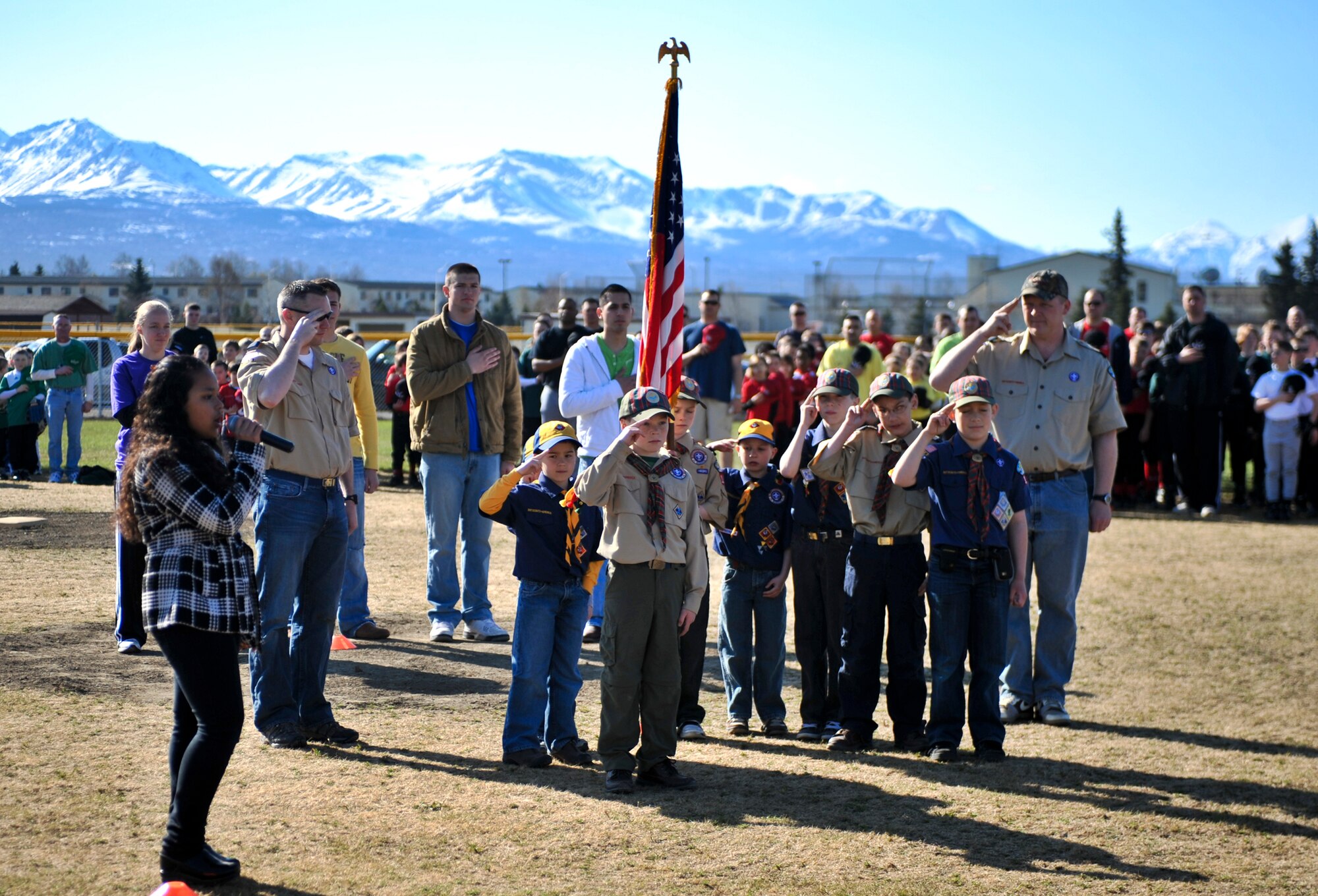 ELMENDORF AIR FORCE BASE, Alaska – Alexis Watkins sings the National Anthem as Elmendorf Den 8 from Cub Scouts Pack 110 presents the colors during the Elmendorf and Fort Richardson 2010 Little League Baseball and Softball opening ceremonies May 8. 