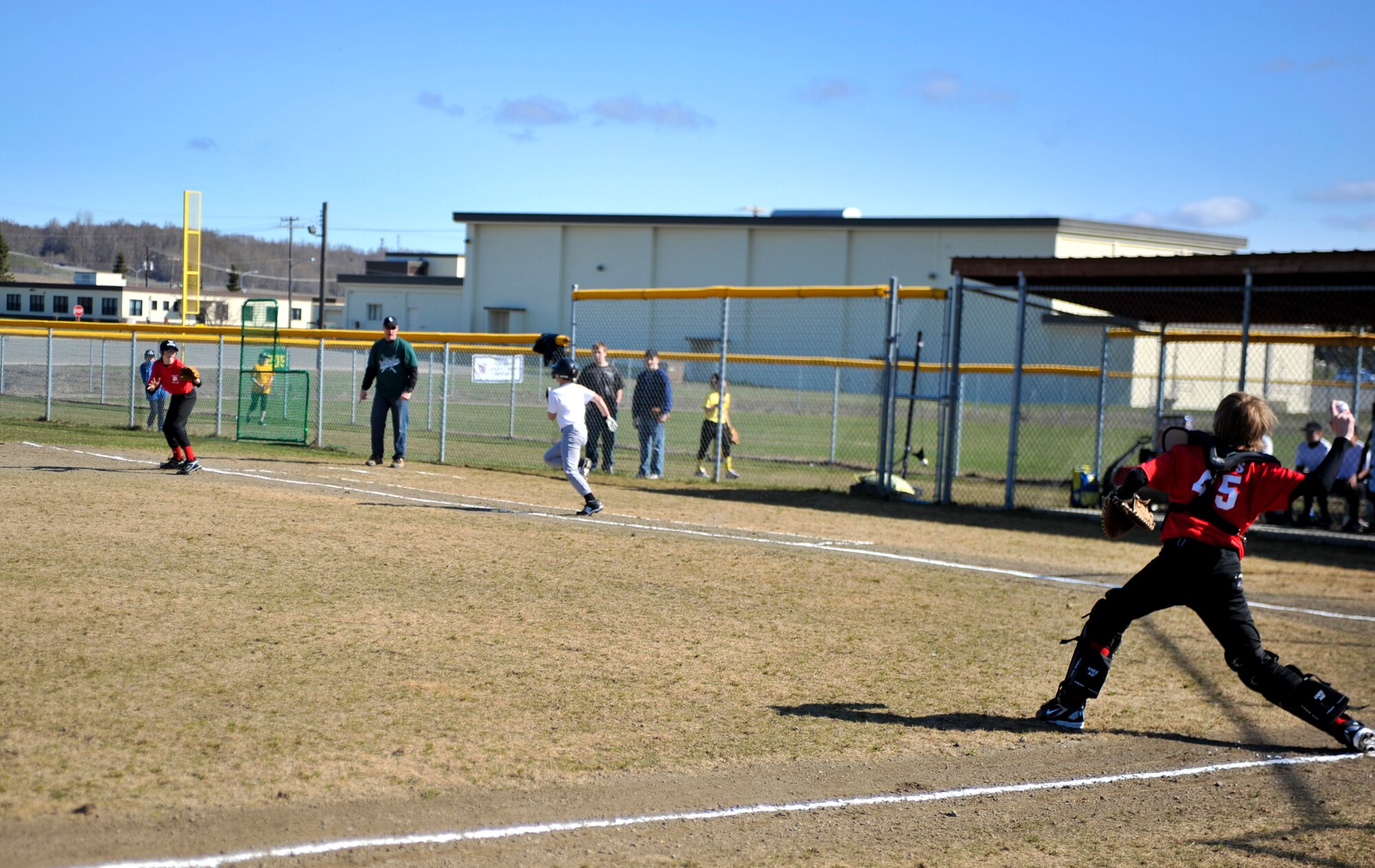 ELMENDORF AIR FORCE BASE, Alaska – A member from an Elmendorf Little League baseball team attempts to throw out a runner from Fort Richardson. The Elmendorf and Fort Richardson 2010 Little League Baseball and Softball opening ceremonies took place May 8. 
