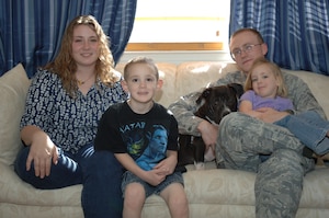 LANGLEY AIR FORCE BASE, Va. -- Athena Holter-Mehren (left) relaxes on her sofa April 29 with (left to right) son Tommy, 5, adopted foster dog Dexter, husband Airman 1st Class Johann Holter-Mehren, 82d Communications Squadron systems administrator, and daughter Chloe, 4. Athena dedicates her time to caring for foster animals, raising her children with an emphasis on education and volunteering in the community. (U.S. Air Force photo/Airman 1st Class Jason J. Brown)
