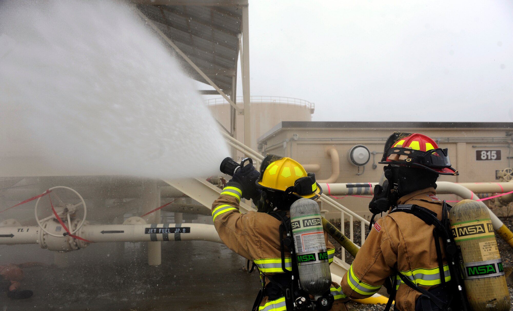 Firefighters extinguish a simulated fire May 5, 2010, Eielson Air Force Base, Alaska. Emergency service Airmen responded to a mock aircraft crash at the fuel storage field during the May operational readiness exercise. The firefighters are part of the 354th Civil Engineer Squadron, Fire Protection Flight. (U.S. Air Force photo/Airman 1st Class Willard E. Grande II)