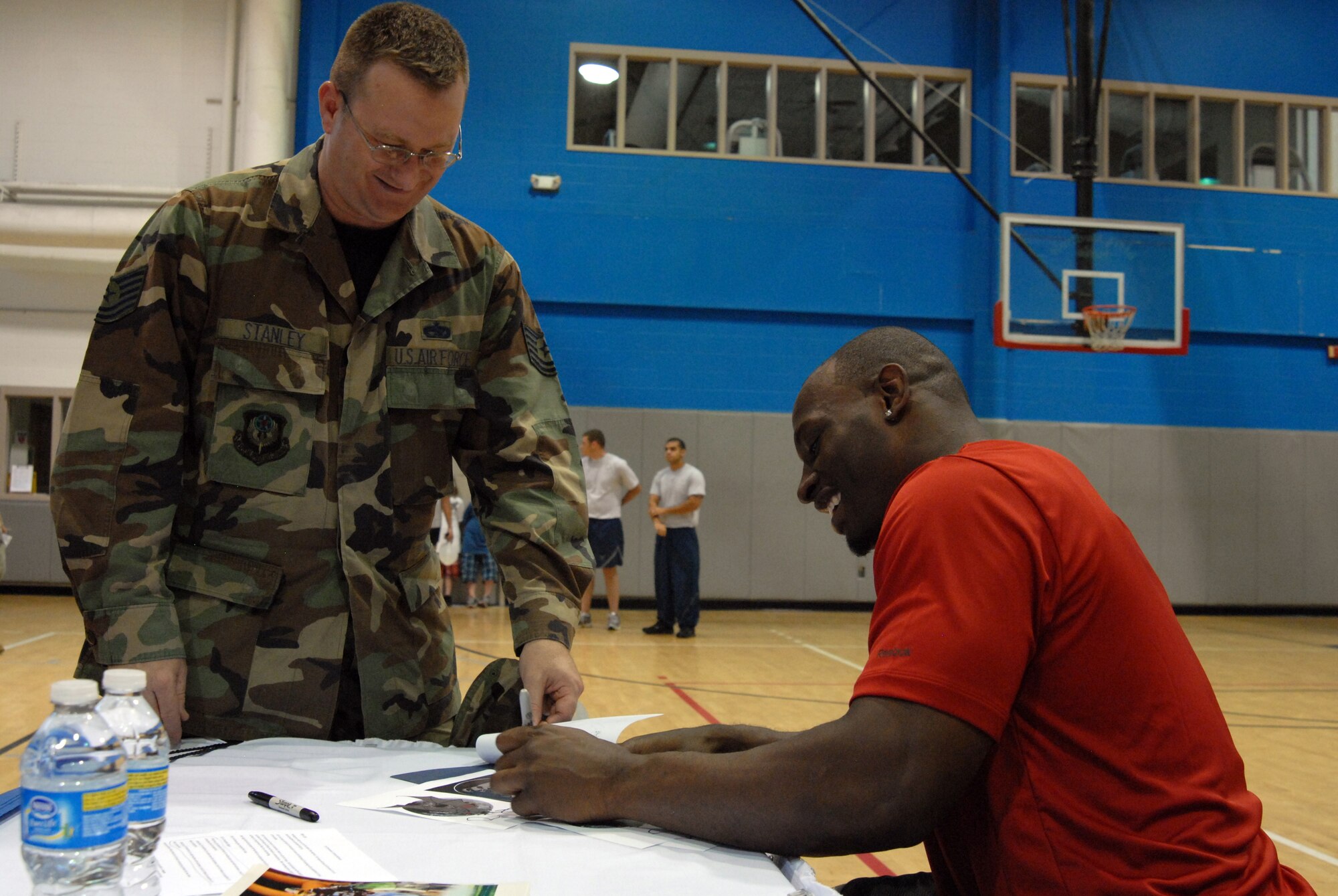 Rocky McIntosh, Washington Redskins linebacker, signs an autograph for Tech. Sgt. Ronald Stanley, 801st Aircraft Maintenance Squadron, during the Air Commandos vs. Rocky McIntosh Competition at Hurlburt Field, Fla., May 4, 2010. Between competition events, the linebacker took time to meet with and sign autographs for fans and event participants. (DoD photo by U. S. Air Force Staff Sgt. Orly N. Tyrell)