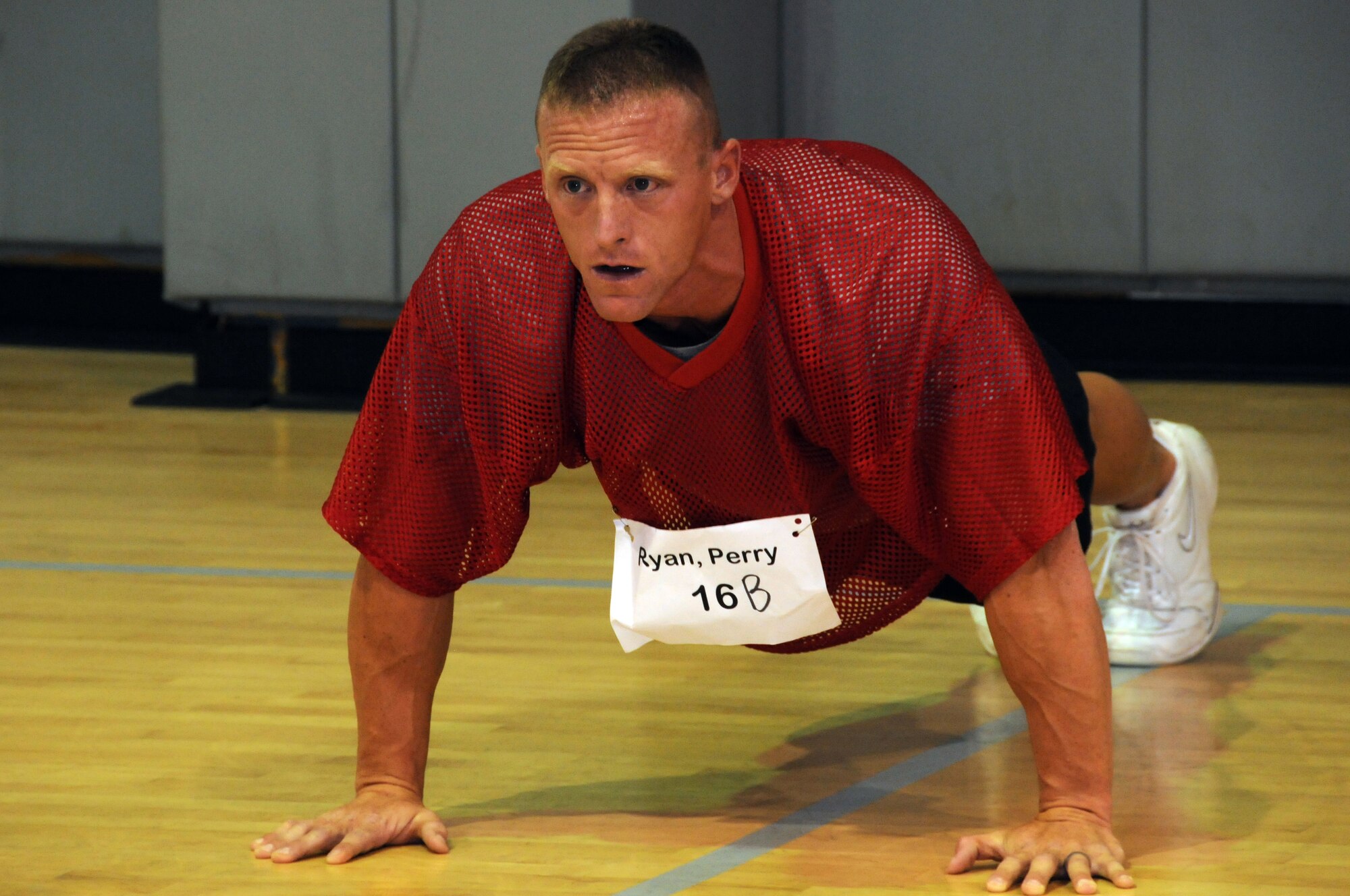 Staff Sgt. Ryan Perry does push-ups during the Air Commandos vs. Rocky McIntosh, #52 Washington Redskins, Competition at Hurlburt Field, Fla., May 4, 2010.  During the competition, Sergeant Perry, 342nd Training Squadron, and other Air Commandos and civilians beat McIntosh in two minutes of push-ups, sit-ups and pull-ups. Senior Airman Terry Cooper, 1st Special Operations Force Support Squadron, topped the charts by obtaining a cumulative score of 263 versus the linebacker's 189.   (U. S. Air Force photo by Reuben Garcia/Released)