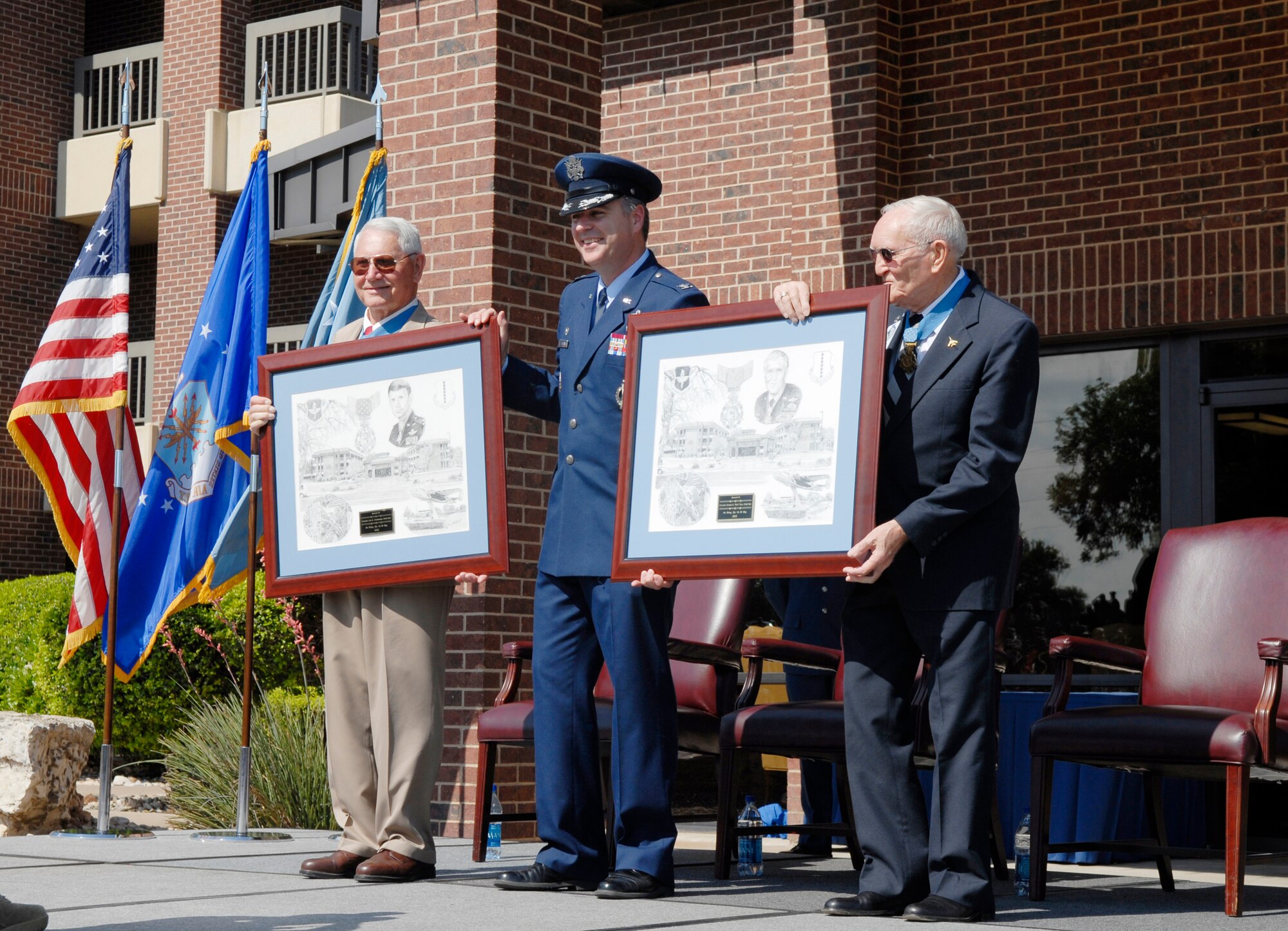 GOODFELLOW AIR FORCE BASE, Texas – Retired Air Force Cols. Leo K. Thorsness and George E. “Bud” Day are presented lithographs by Colonel Thomas Geary, 17th Training Wing commander, May 7, 2010. Two Visiting Officer Quarters were named in honor of Colonels Day and Thorsness, both of whom received the Medal of Honor for actions while serving in Vietnam. (U.S. Air Force photo/Lou Czarnecki)