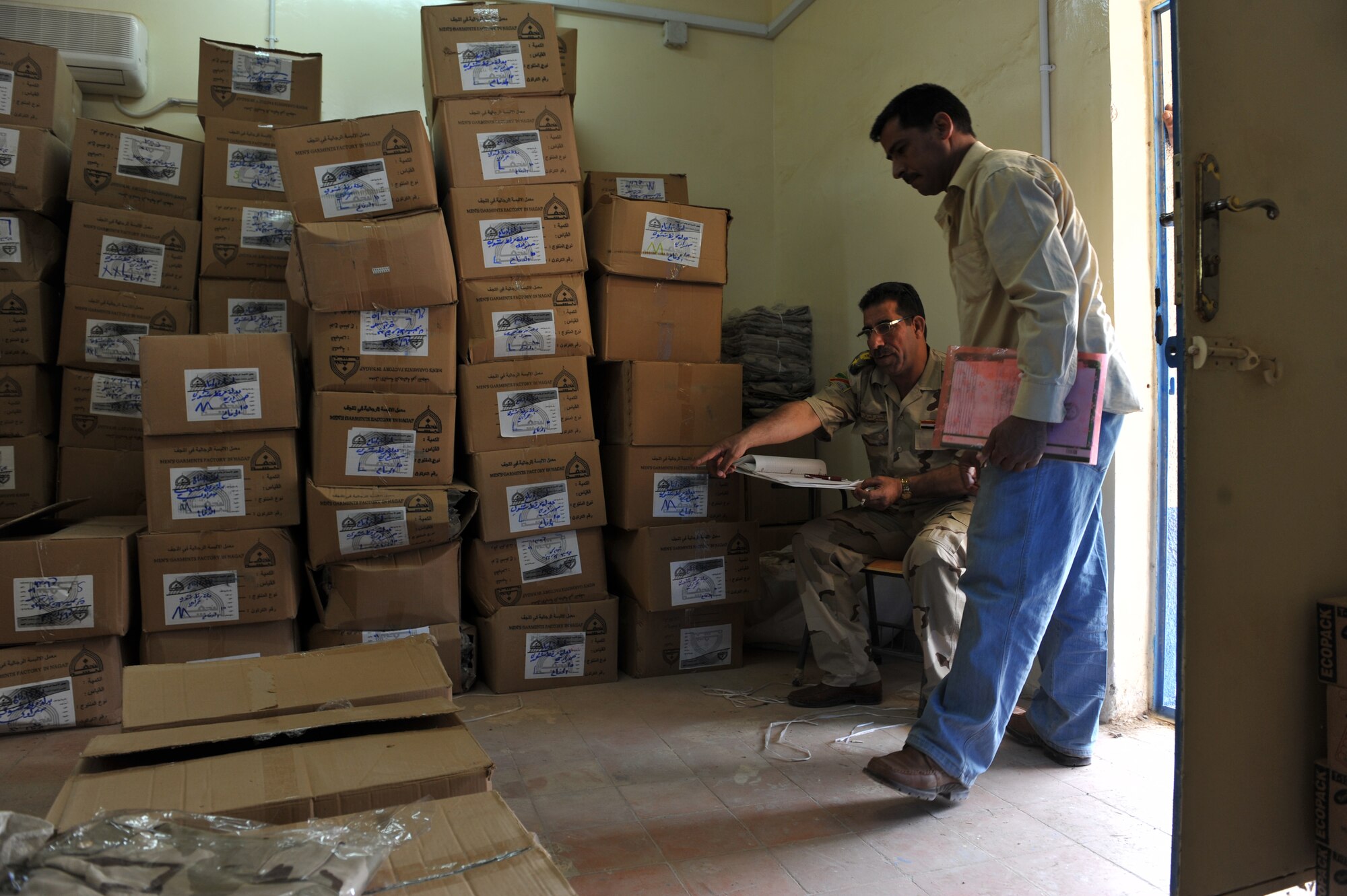 Iraqi Air Force Training School BMT Director Lt. Col. Ali Hussein Muhaimeed points to uniforms for an Iraqi recruit at the Iraqi Air Force Training School, Camp Taji, Iraq, April 19, 2010. The Iraqi airman volunteered to return to active duty through the rehire program by the Ministry of Defense.  (U.S. Air Force photo/Staff Sgt Quinton Russ/released)