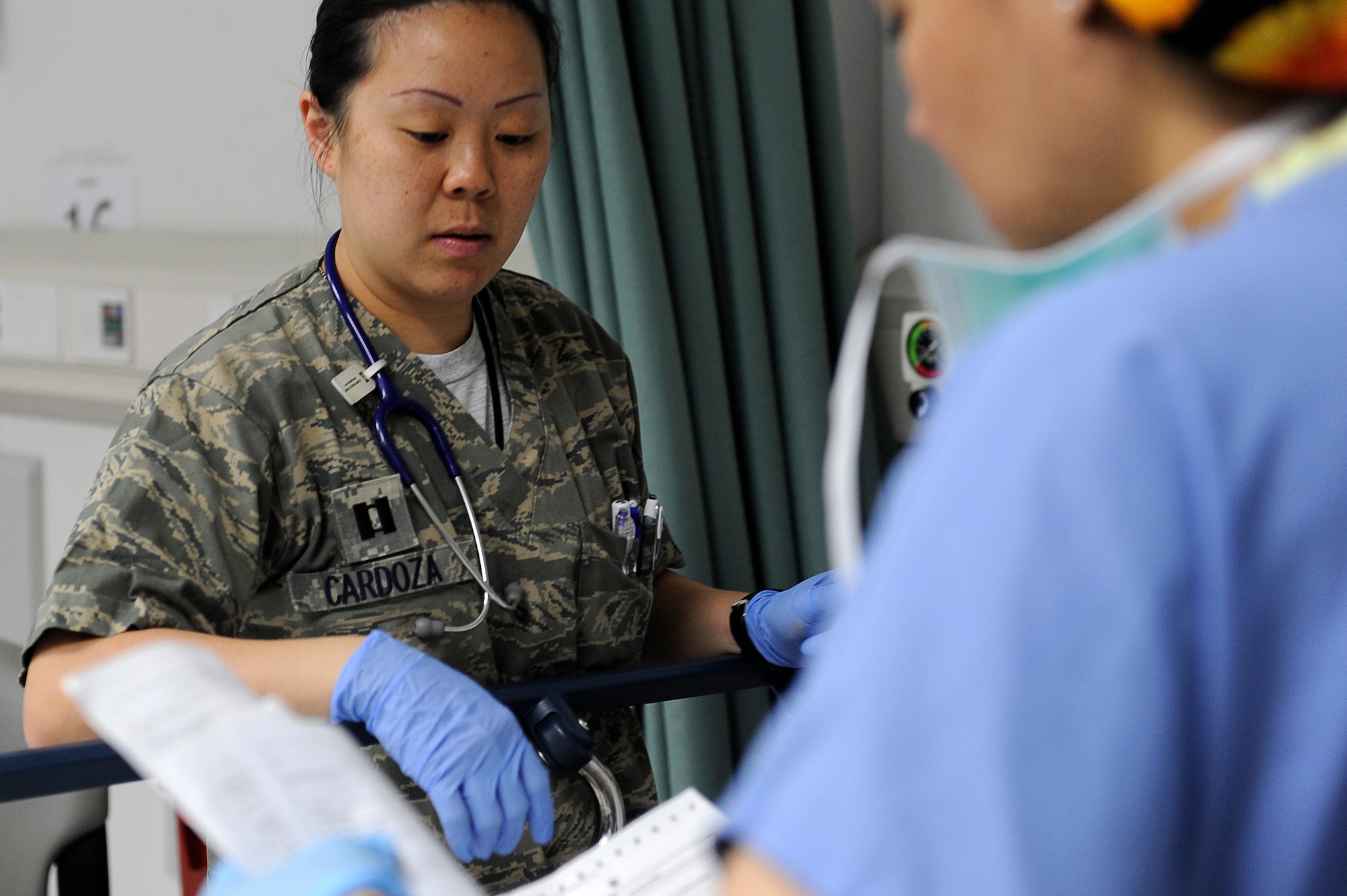 U.S. Air Force Capt. Christine Cardoza, 455th Expeditionary Medical Group/Task Force Medical East, gets briefed on the status of a patient after surgery at the Craig Joint Theater Hospital, Bagram Airfield, Afghanistan, May 5, 2010. Captain Cardoza is deployed from Nellis Air Force Base, Nev., and is from Dayton, Ohio. (U.S. Air Force photo by/ Master Sgt. Jeromy K. Cross/released)