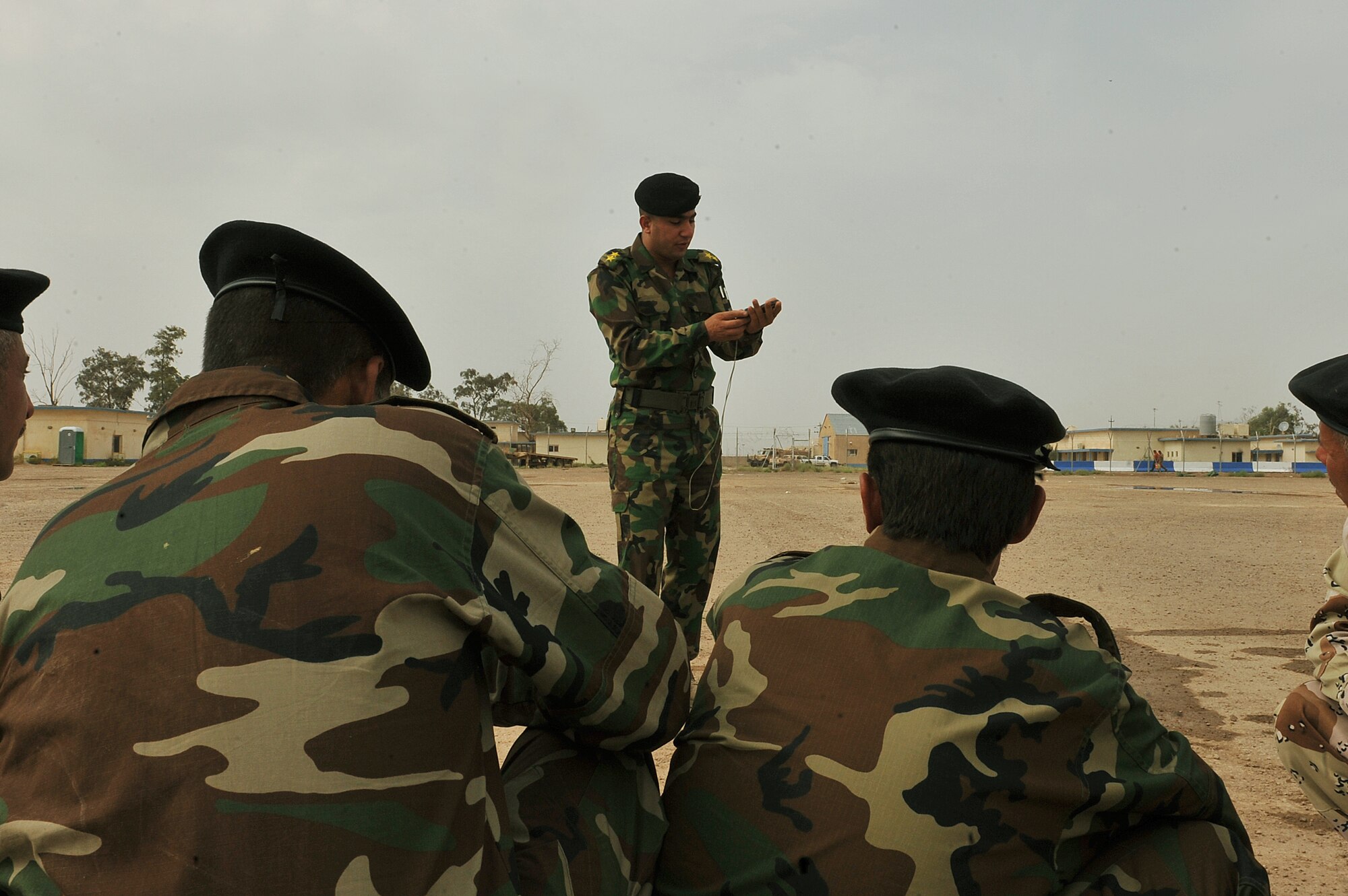 Iraqi Air Force Basic Training Instructor 1st Lt. Ammar Hamed shows a group of Iraqi airmen how to use a compass during land-navigation class at the Iraqi Air Force Training School in Camp Taji, Iraq, April 18, 2010. The Iraqi airmen volunteered to return to active duty through the rehire program by the Ministry of Defense.  (U.S. Air Force photo/Staff Sgt Quinton Russ/released)