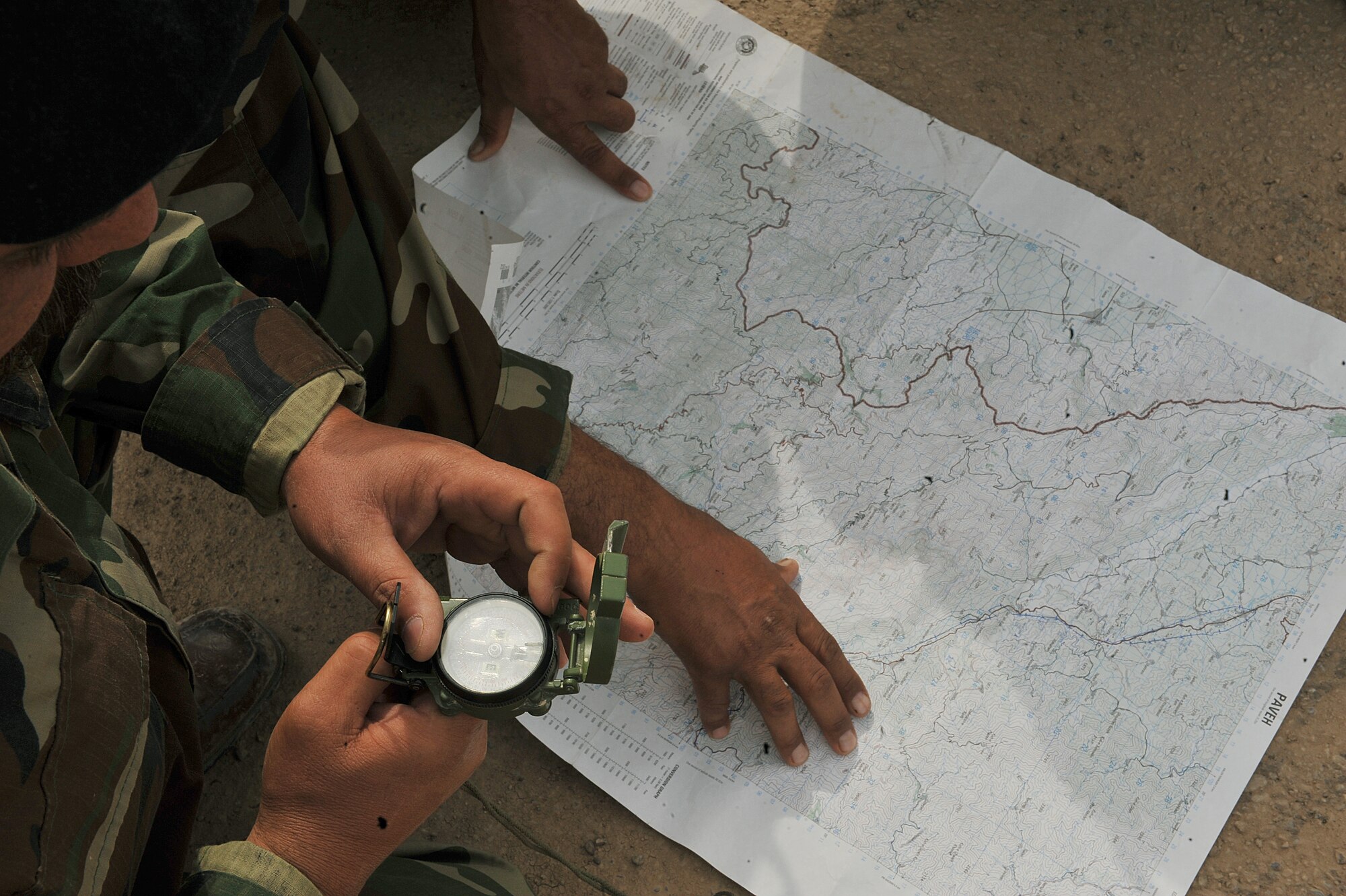 Iraqi Air Force airmen use a map and compass during the land navigation portion of their BMT Top Off training at Camp Taji, Iraq, April 18, 2010. The Iraqi airmen volunteered to return to active duty through the rehire program by the Ministry of Defense.  (U.S. Air Force photo/Staff Sgt Quinton Russ/released)