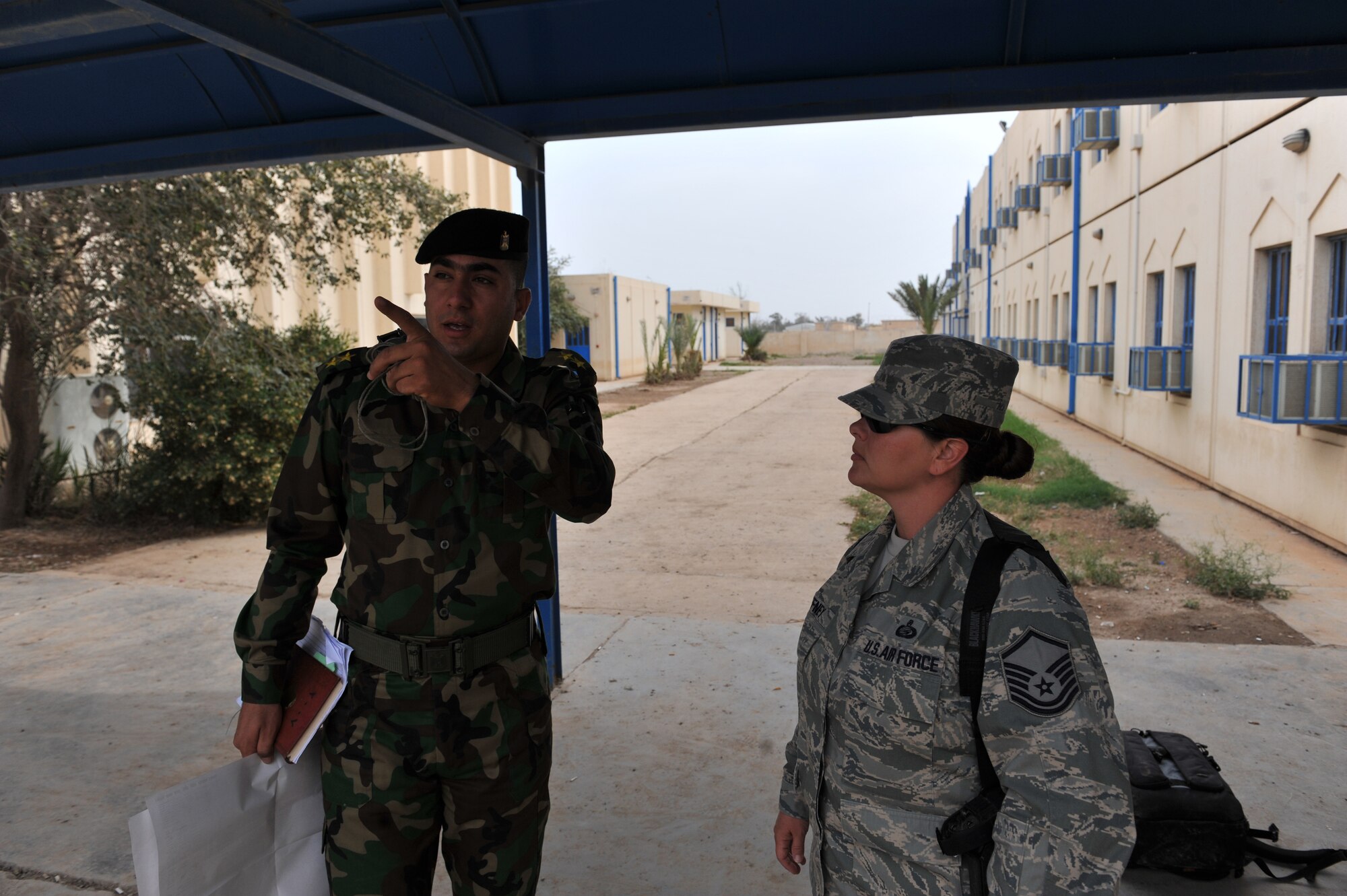 Iraqi Air Force Instructor 1st Lt. Ammar Hamed tells U.S. Air Force Master Sgt. Paula Gaffney the sequence of events for the day's lesson at Camp Taji, Iraq, April 18, 2010. Sergeant Gaffney is a Basic Military Instructor and advisor to the Iraqi Air Force and is deployed from the 326th Training Squadron, Lackland Air Force Base, Texas. She is forward deployed to the 821st Expeditionary Training Squadron.  (U.S. Air Force photo/Staff Sgt Quinton Russ/released)
