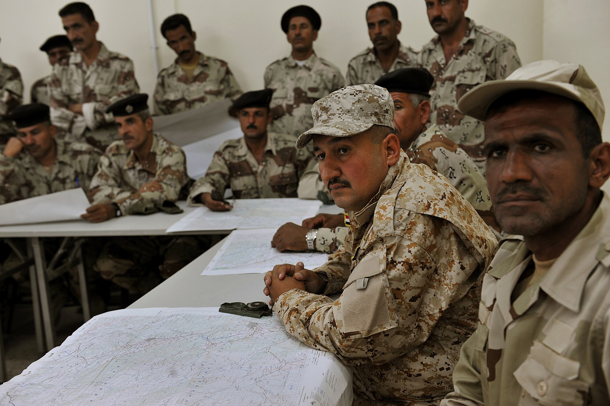 Iraqi Air Force basic training students sit and listen during a land-navigation class at the Iraqi Air Force Training School in Camp Taji, Iraq, April 18, 2010. The Iraqi airmen volunteered to return to active duty through the rehire program by the Ministry of Defense.   (U.S. Air Force photo/Staff Sgt Quinton Russ/released)