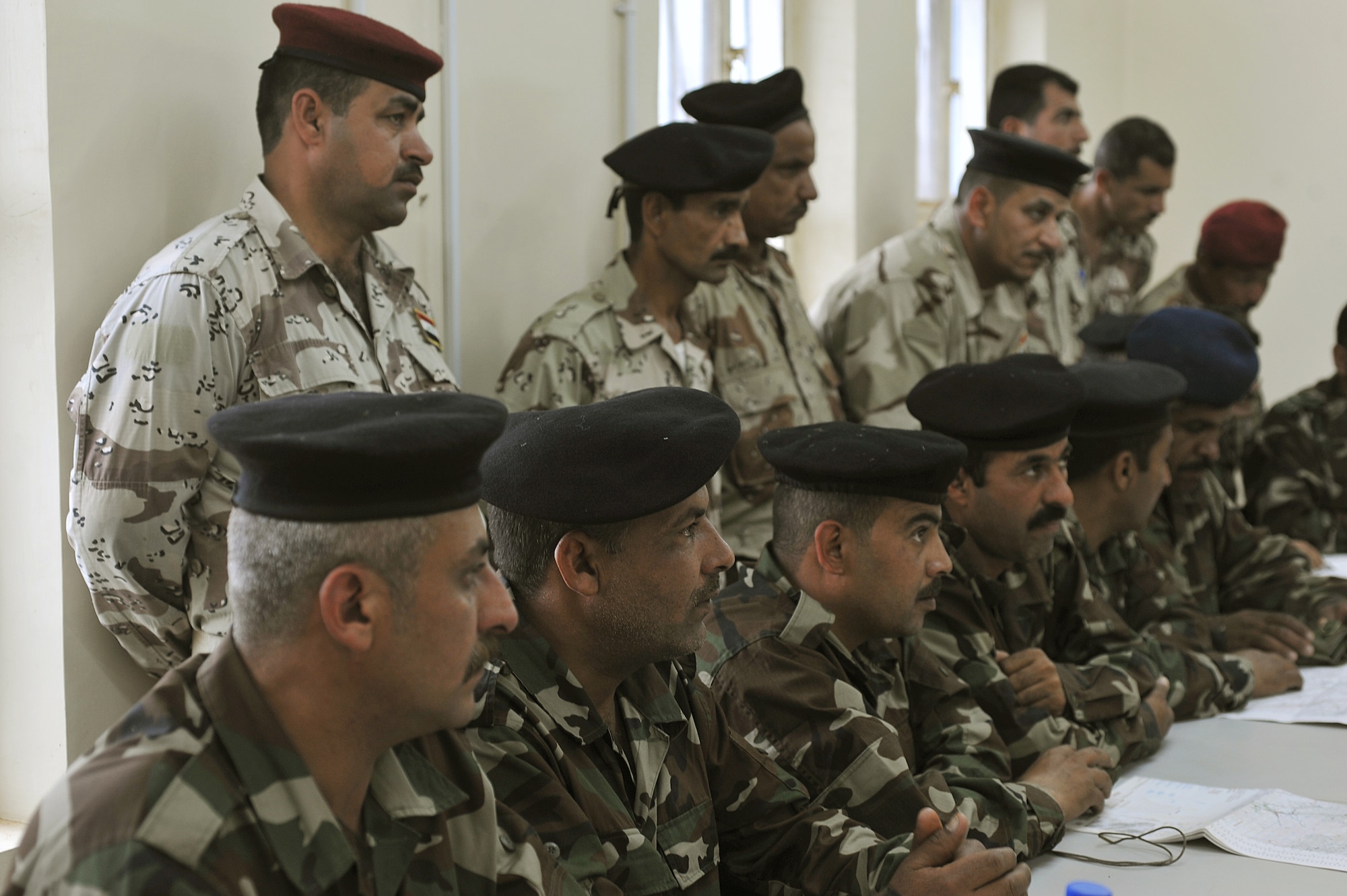 Iraqi Air Force Basic Training students sit and listen during a land-navigation class at the Iraqi Air Force Training School in Camp Taji, Iraq, April 18, 2010. The Iraqi airmen volunteered to return to active duty through the rehire program by the Ministry of Defense.  (U.S. Air Force photo/Staff Sgt Quinton Russ/released)