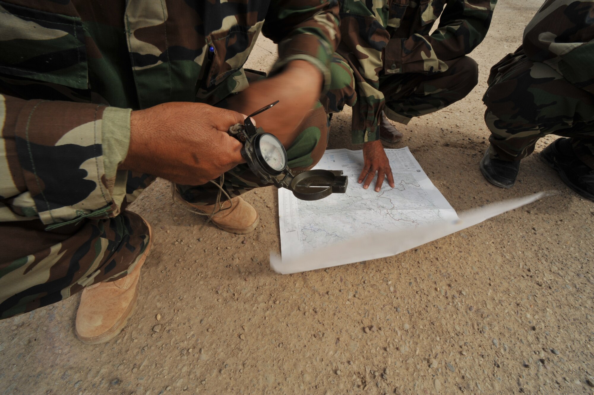 Iraqi Air Force airmen use a map and compass during the land-navigation portion of their BMT Top Off training at Camp Taji, Iraq, April 18, 2010. The Iraqi airmen volunteered to return to active duty through the rehire program by the Ministry of Defense.   (U.S. Air Force photo/Staff Sgt Quinton Russ/released)