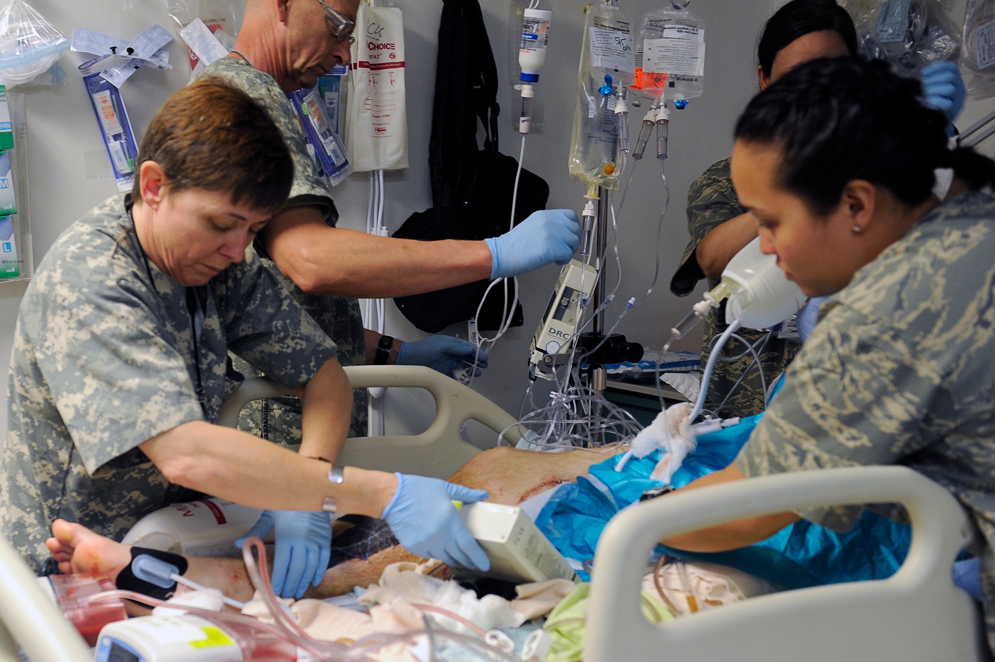 U.S. Air Force nurses and medical technicians from the 455th Expeditionary Medical Group/Task Force Medical East set up equipment for a patient after surgery in the intensive care unit at the Craig Joint Theater Hospital, Bagram Airfield, Afghanistan, May 5, 2010. (U.S. Air Force photo by/ Master Sgt. Jeromy K. Cross/released)