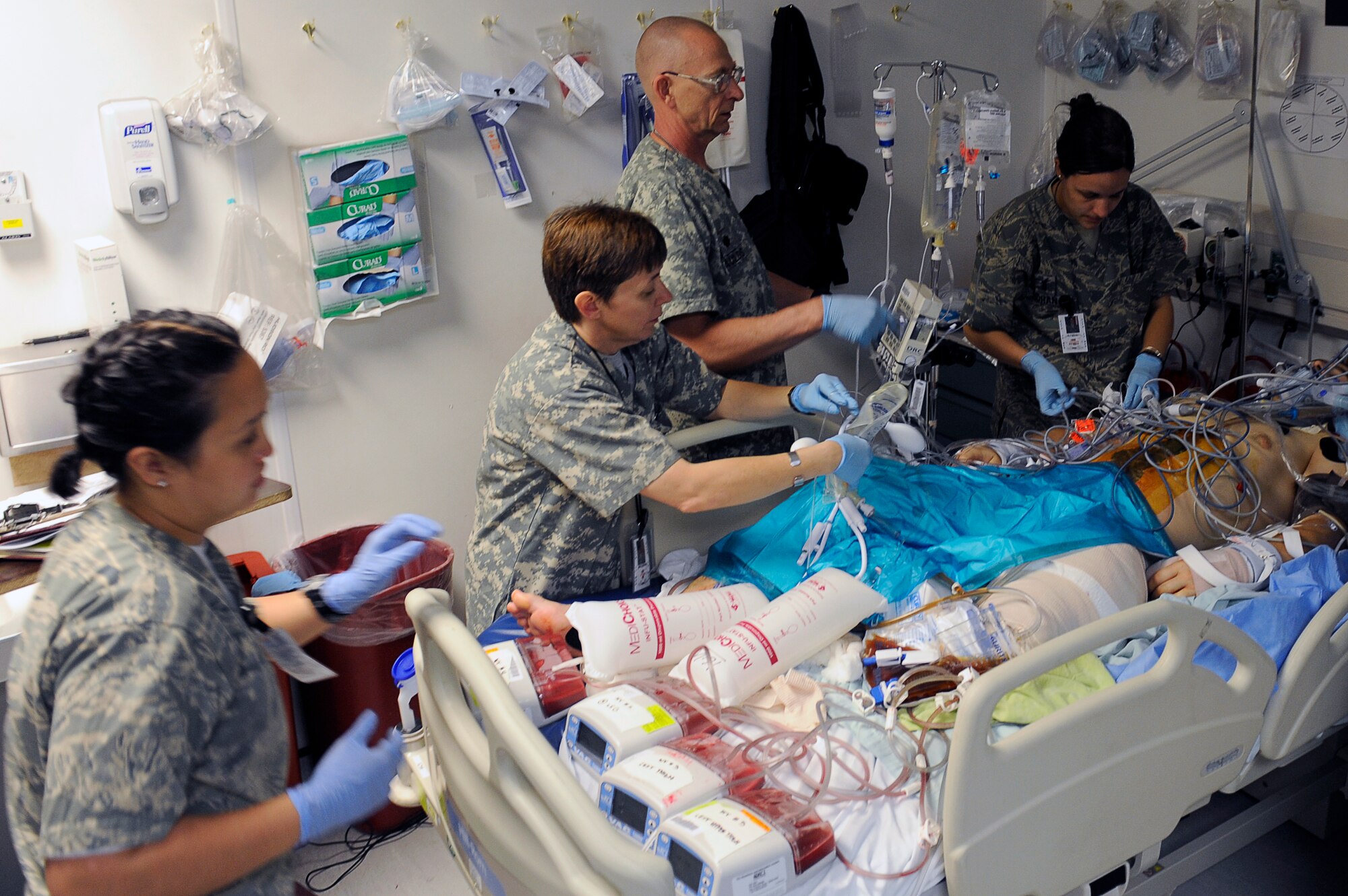 U.S. Air Force nurses and medical technicians from the 455th Expeditionary Medical Group/Task Force Medical East set up equipment for a patient after surgery in the intensive care unit at the Craig Joint Theater Hospital, Bagram Airfield, Afghanistan, May 5, 2010. (U.S. Air Force photo by/ Master Sgt. Jeromy K. Cross/released)